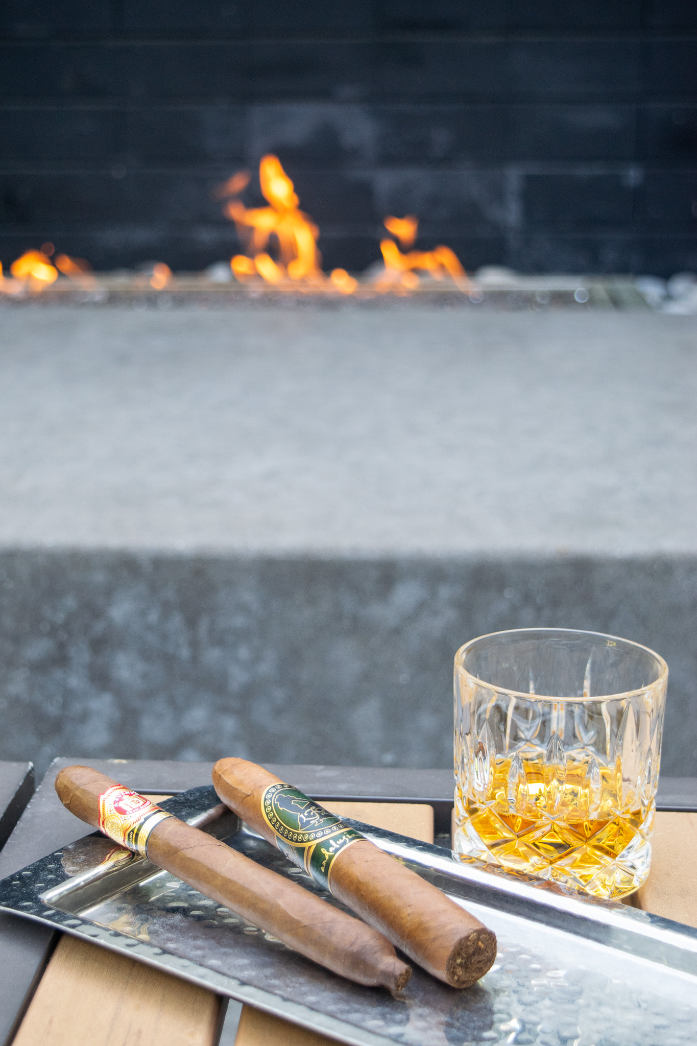 Two cigars on a tray with fire in the background on the Le Meridien Atlanta Perimeter Hotel
