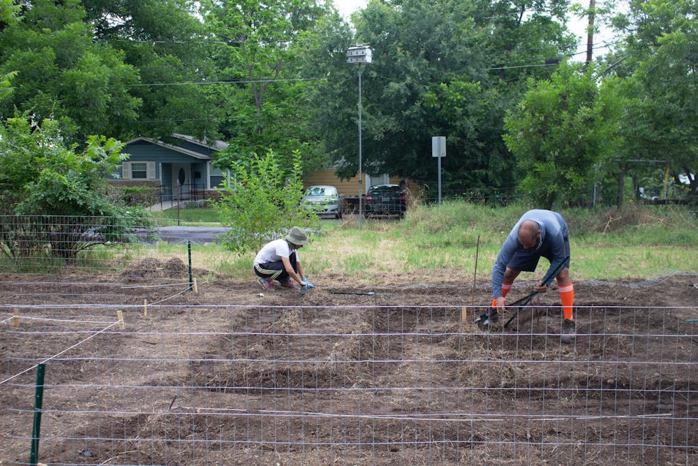 a group of people standing on top of a dirt field