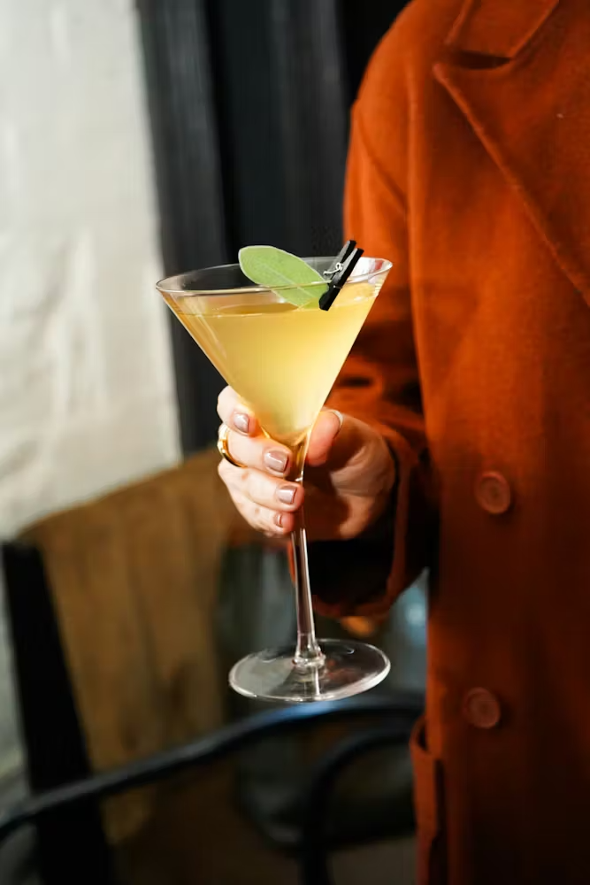 a person sitting at a table with a glass of wine