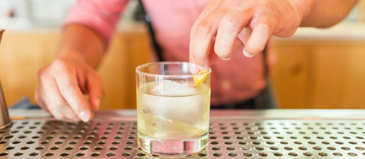 A bartender skillfully mixes a drink