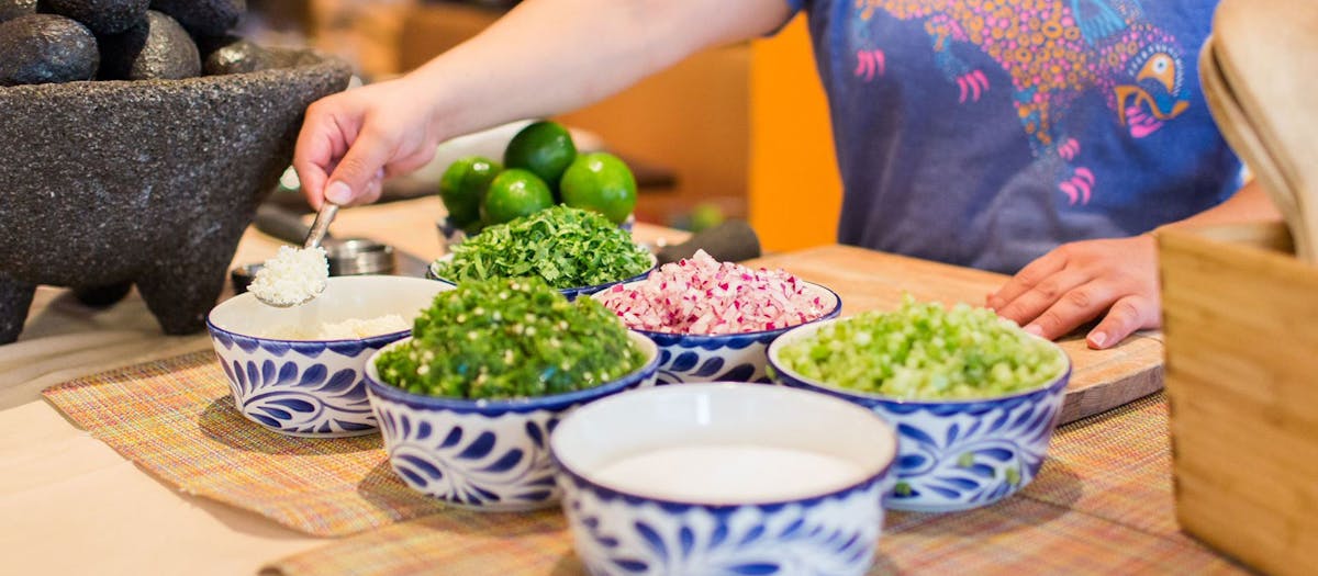 A woman is skillfully preparing food on a kitchen counter