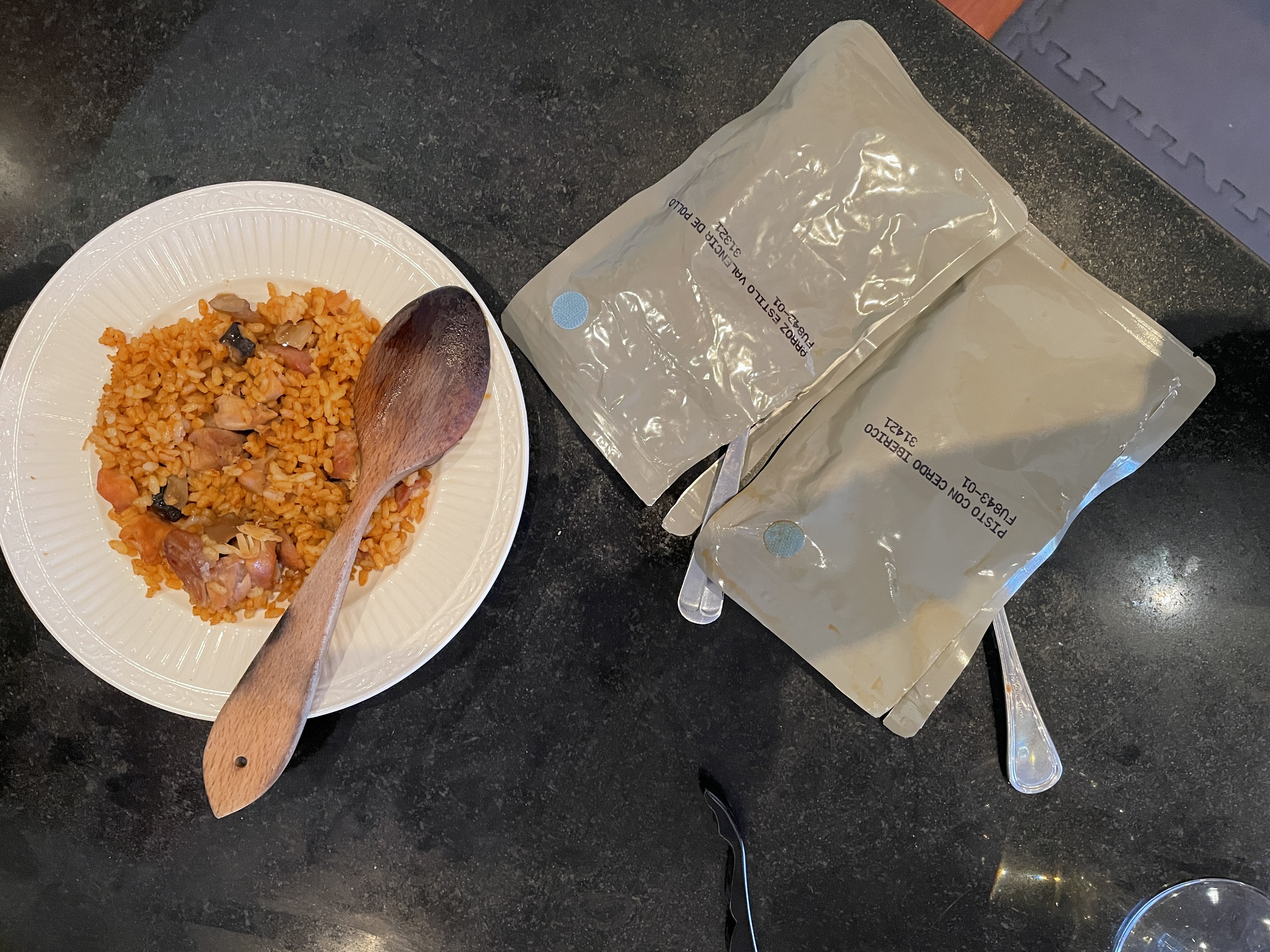 a plate with paella and two spoons