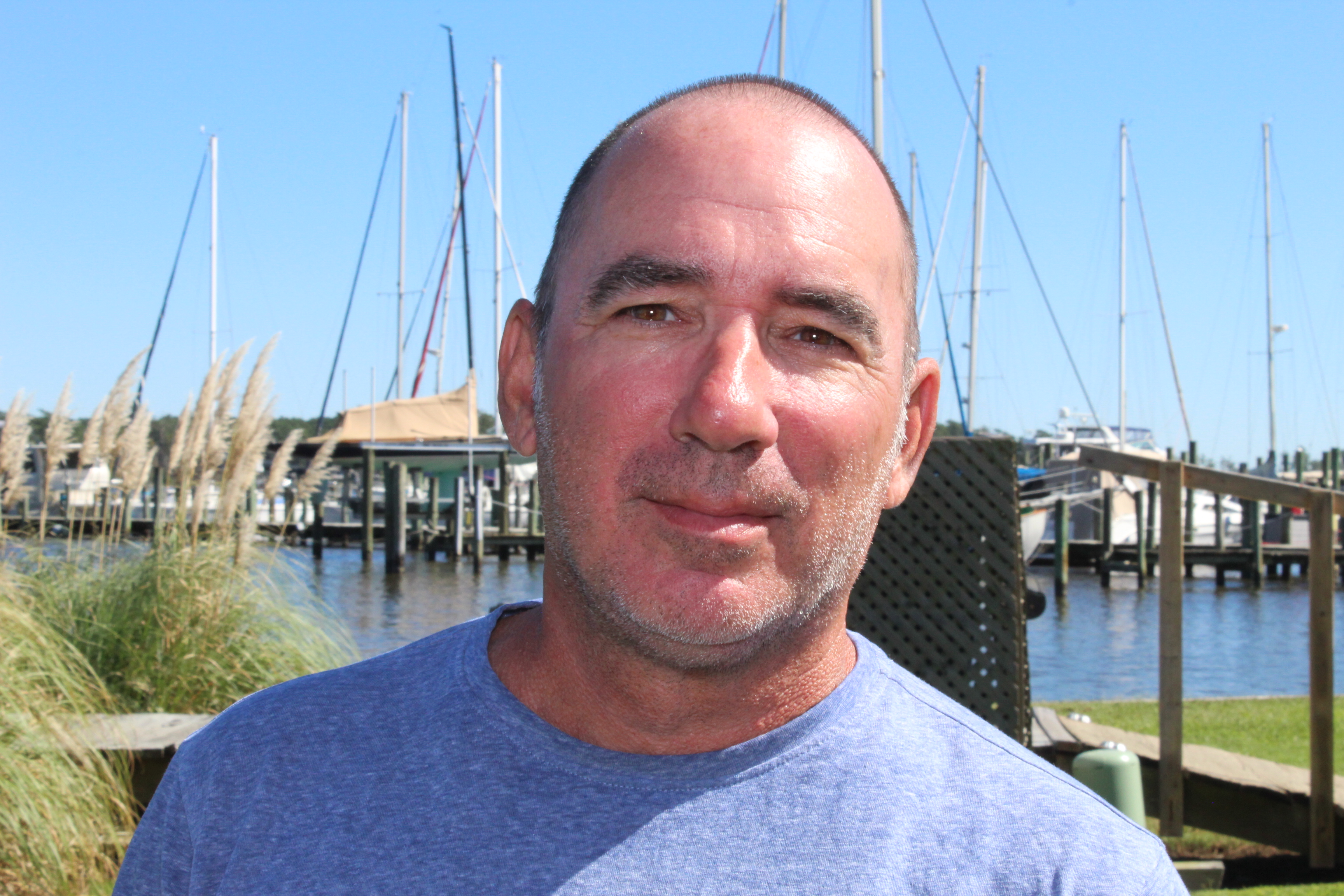 a man smiling next to a body of water