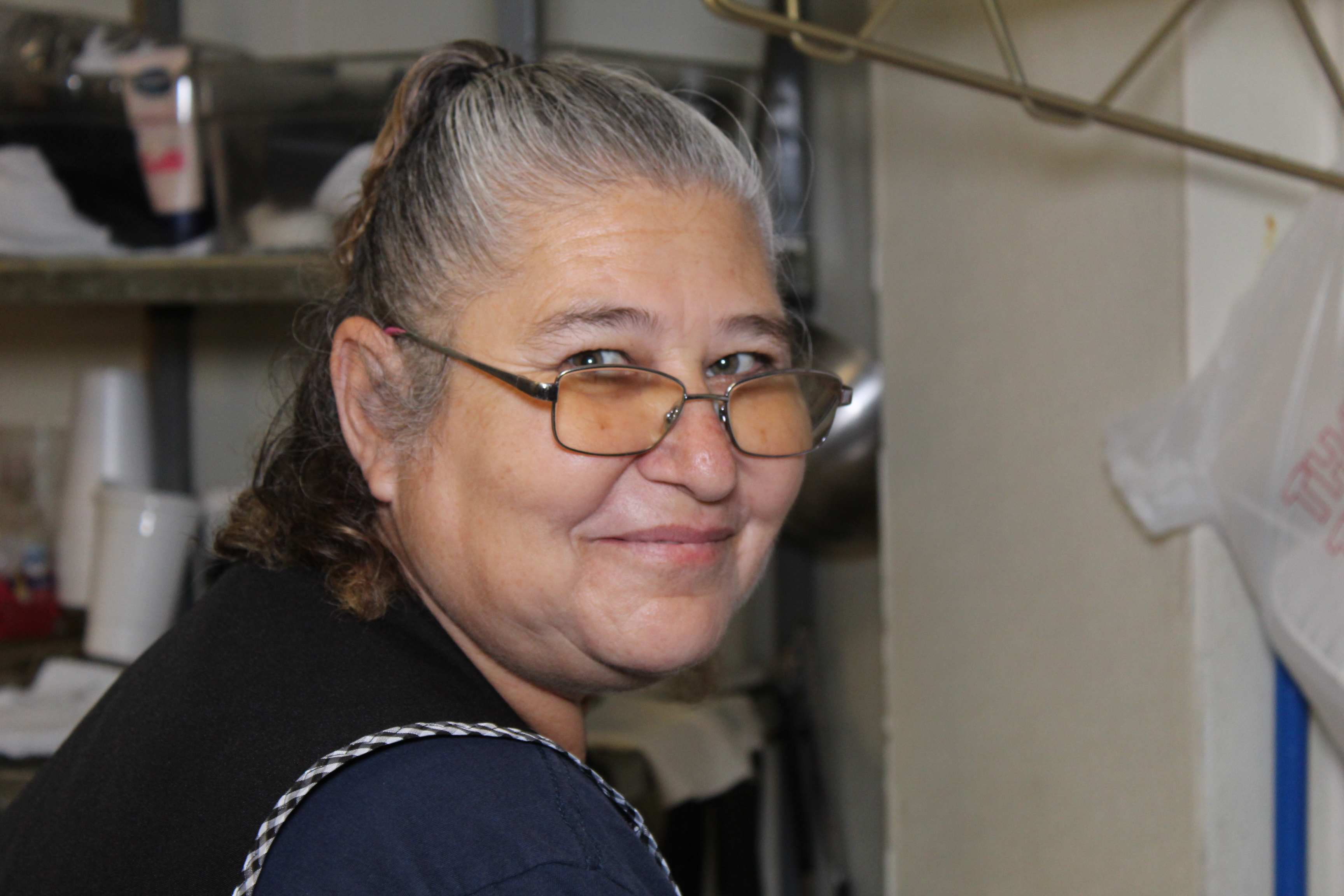 a person wearing glasses and smiling at the camera