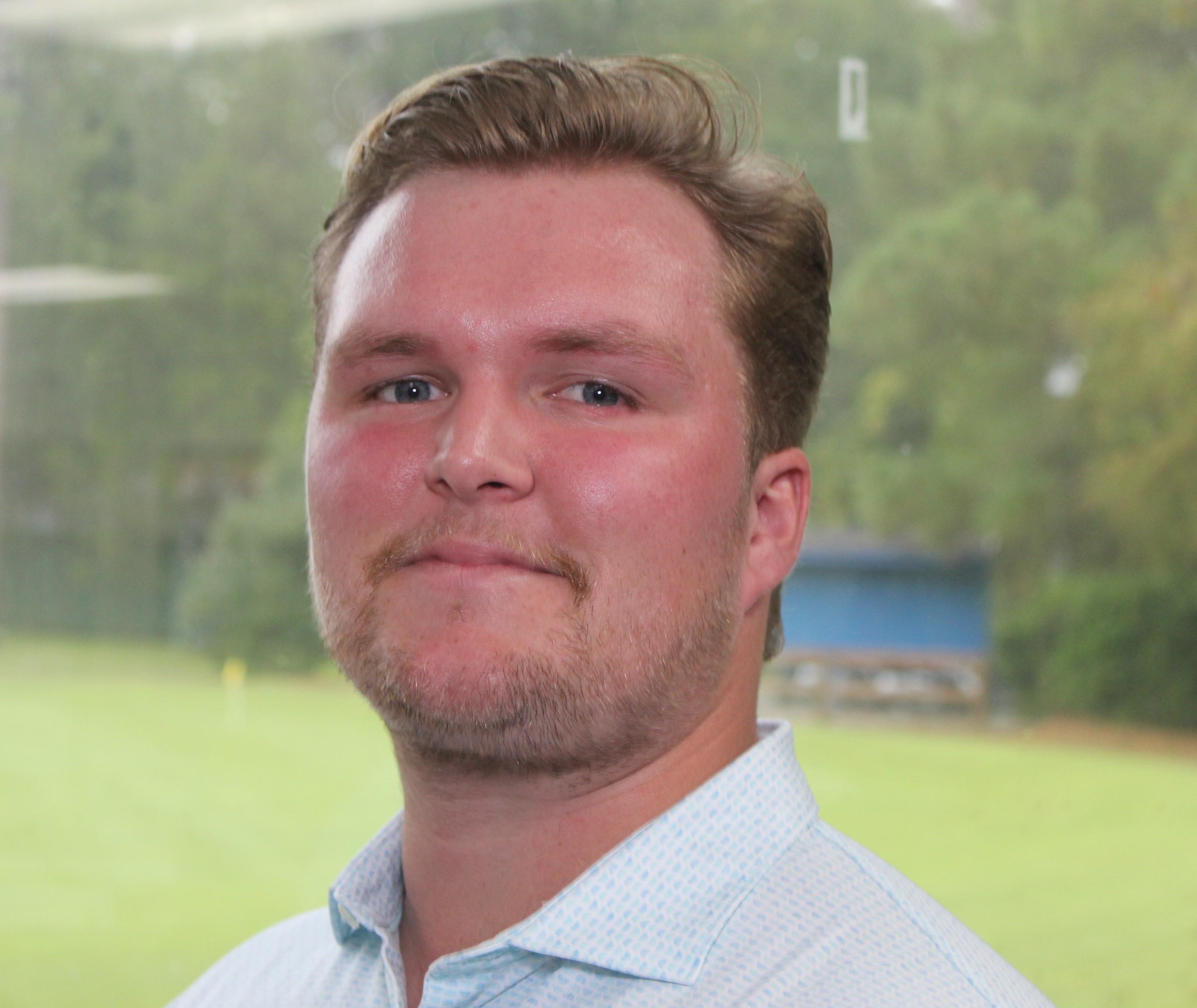 a man wearing glasses and smiling at the camera
