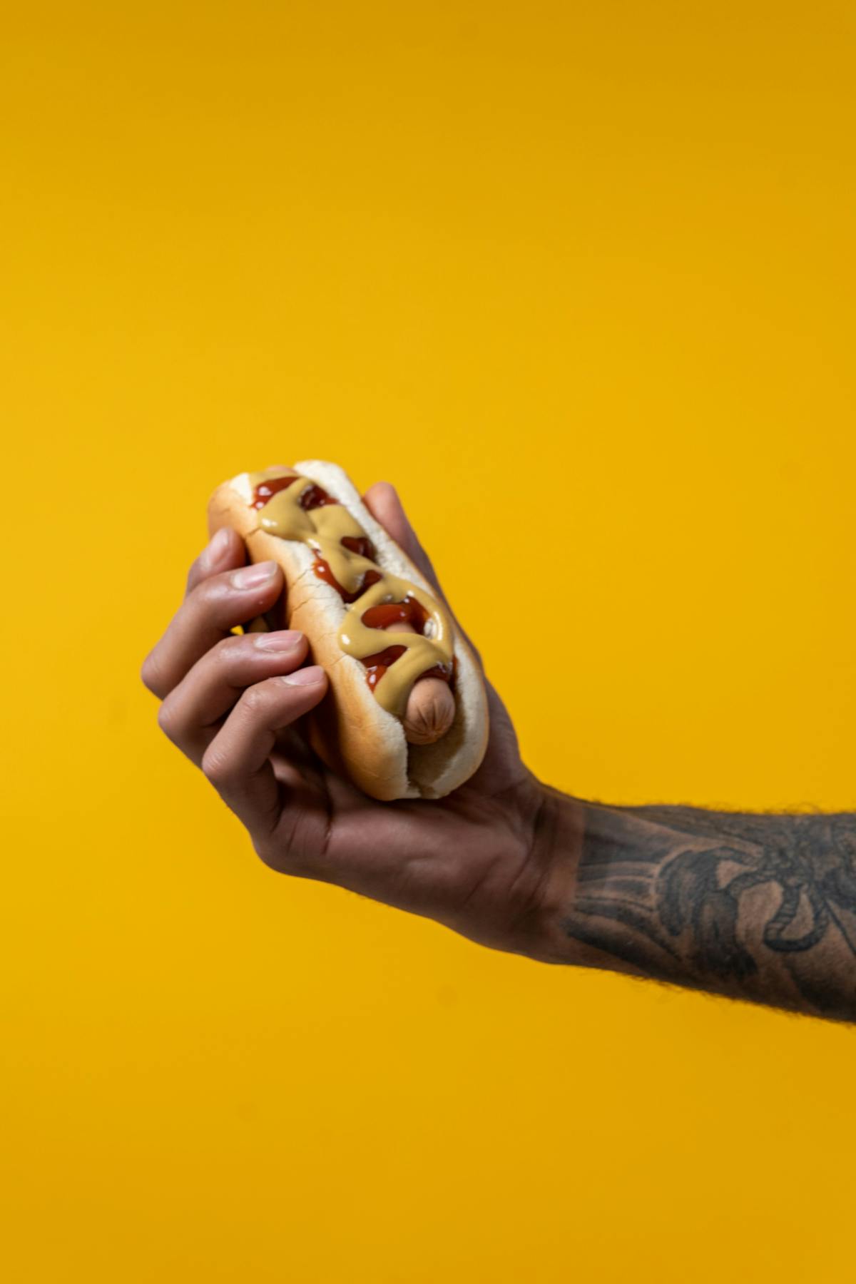 a hand holding a hot dog