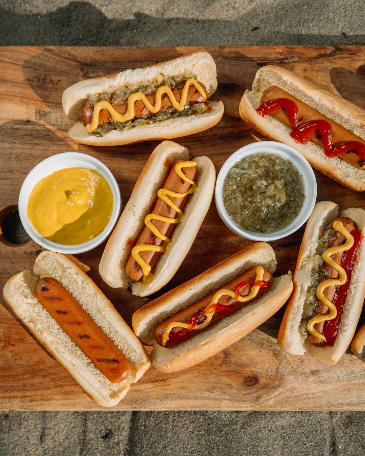 a bunch of hot dogs with different toppings