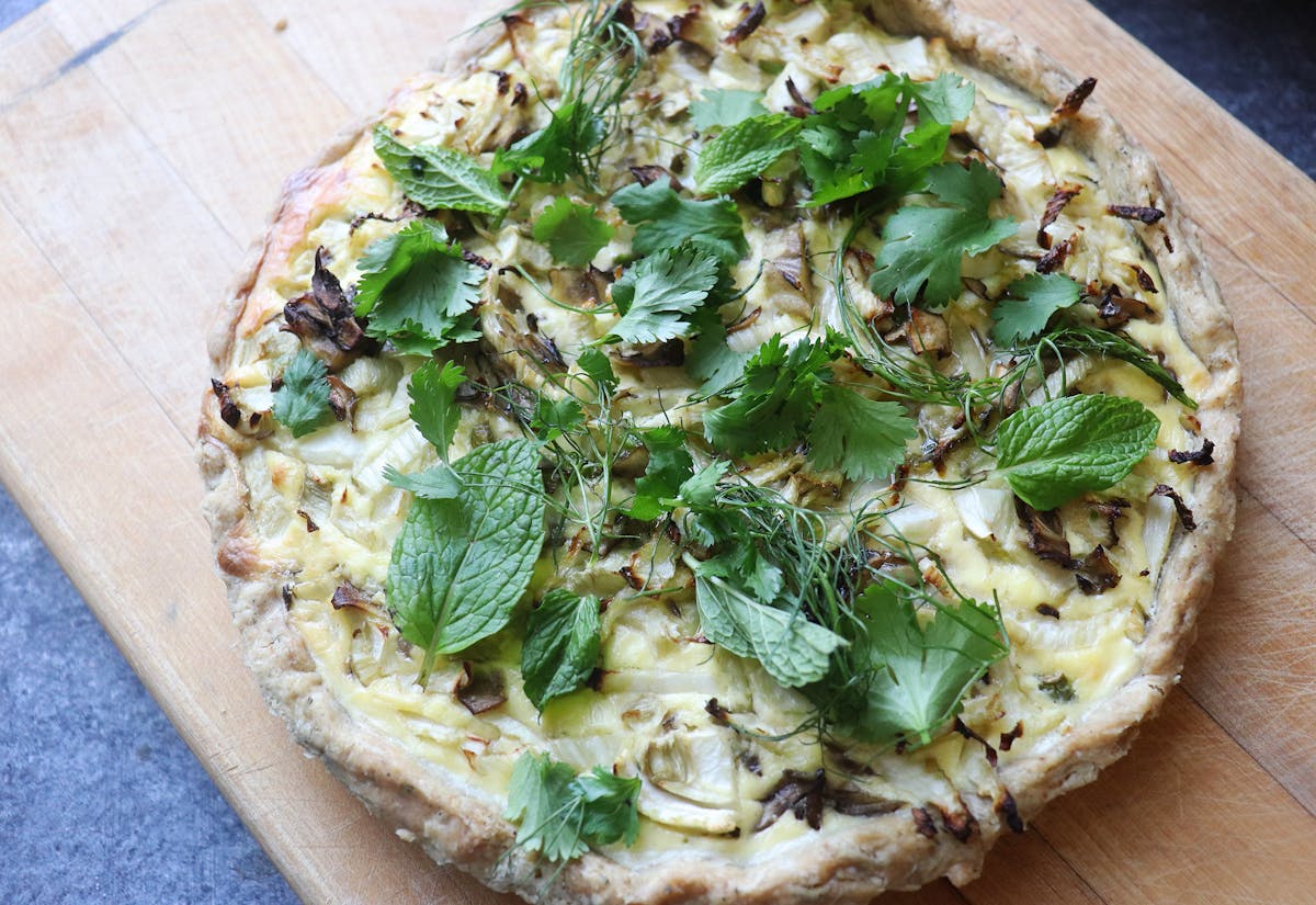 a pizza sitting on top of a wooden cutting board