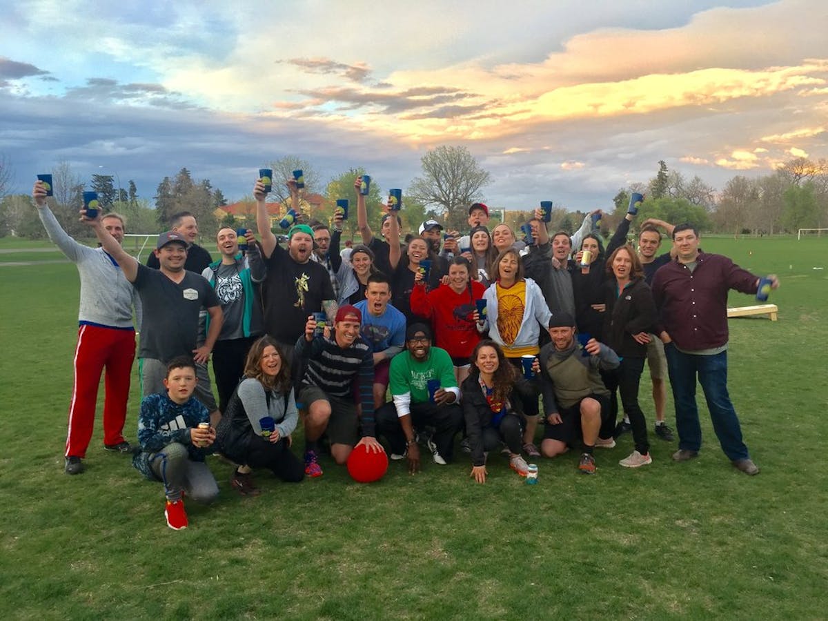 a group of people standing in a grass field posing for the camera