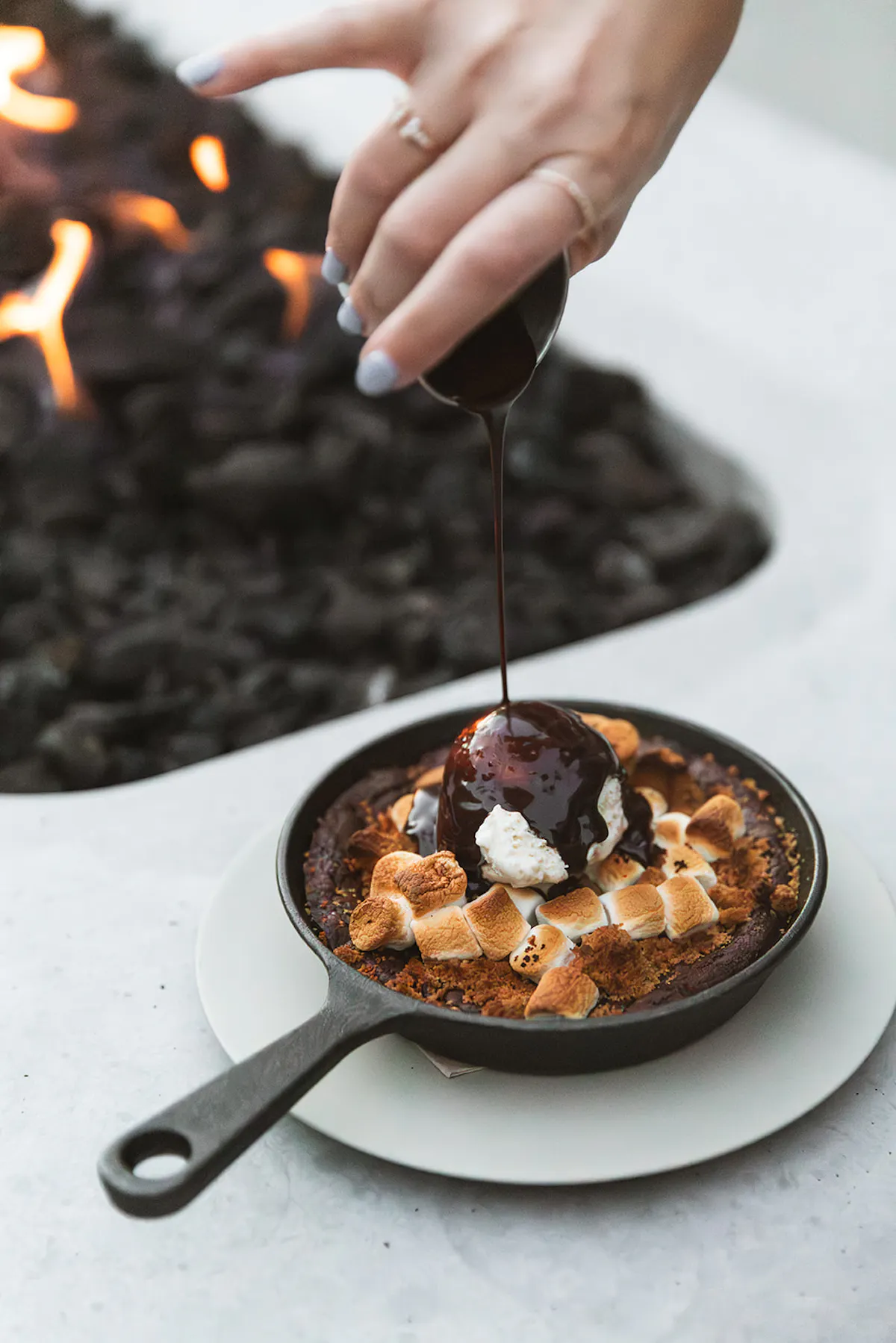a person pouring syrup on a dessert