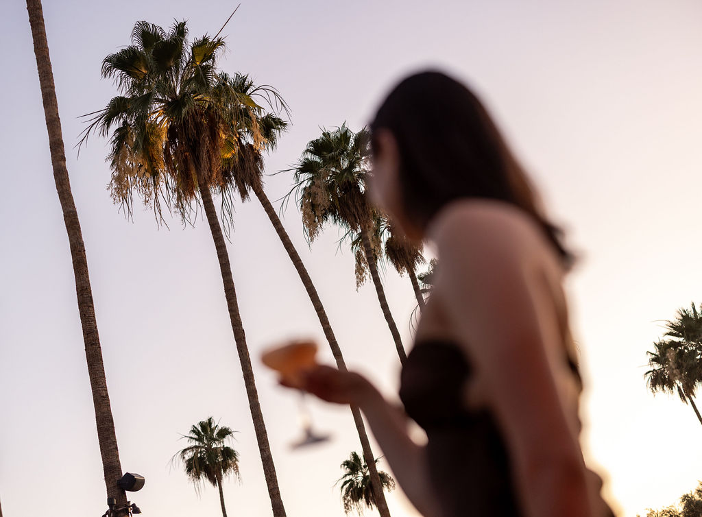 a woman holding a glass with a drink in her hand