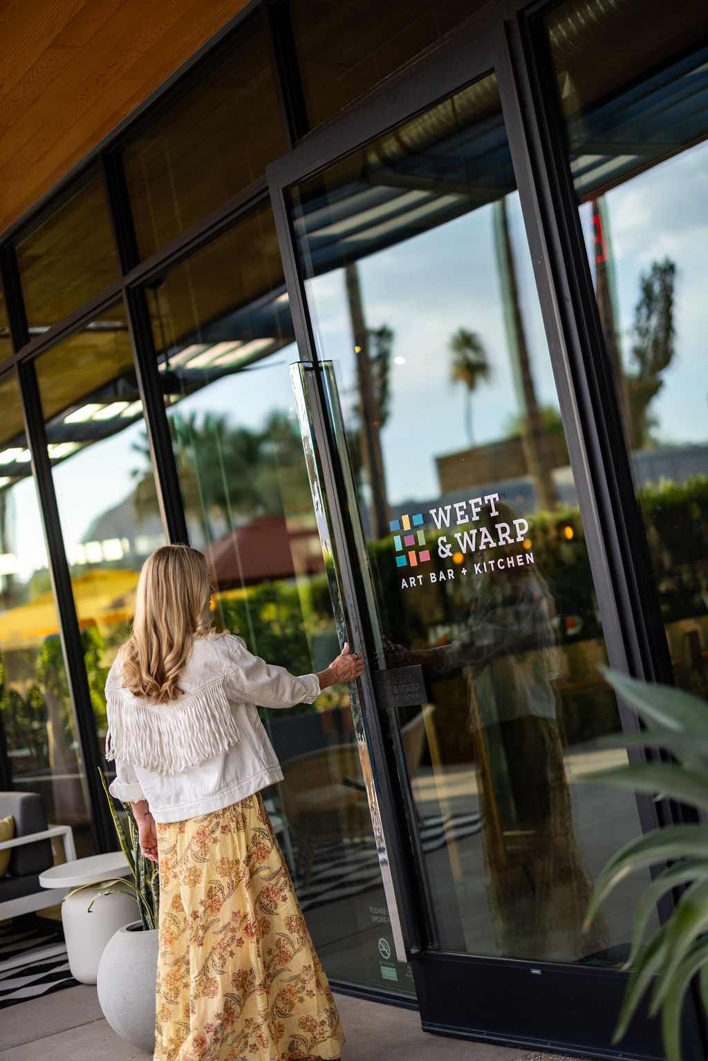 a woman opening a glass door