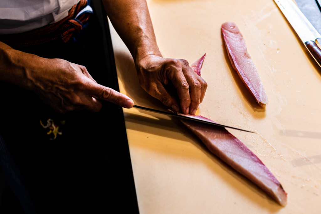a person sitting at a table with a knife