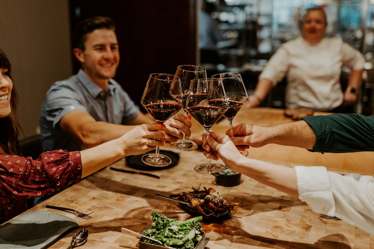 a group of people sitting at a table with pizza