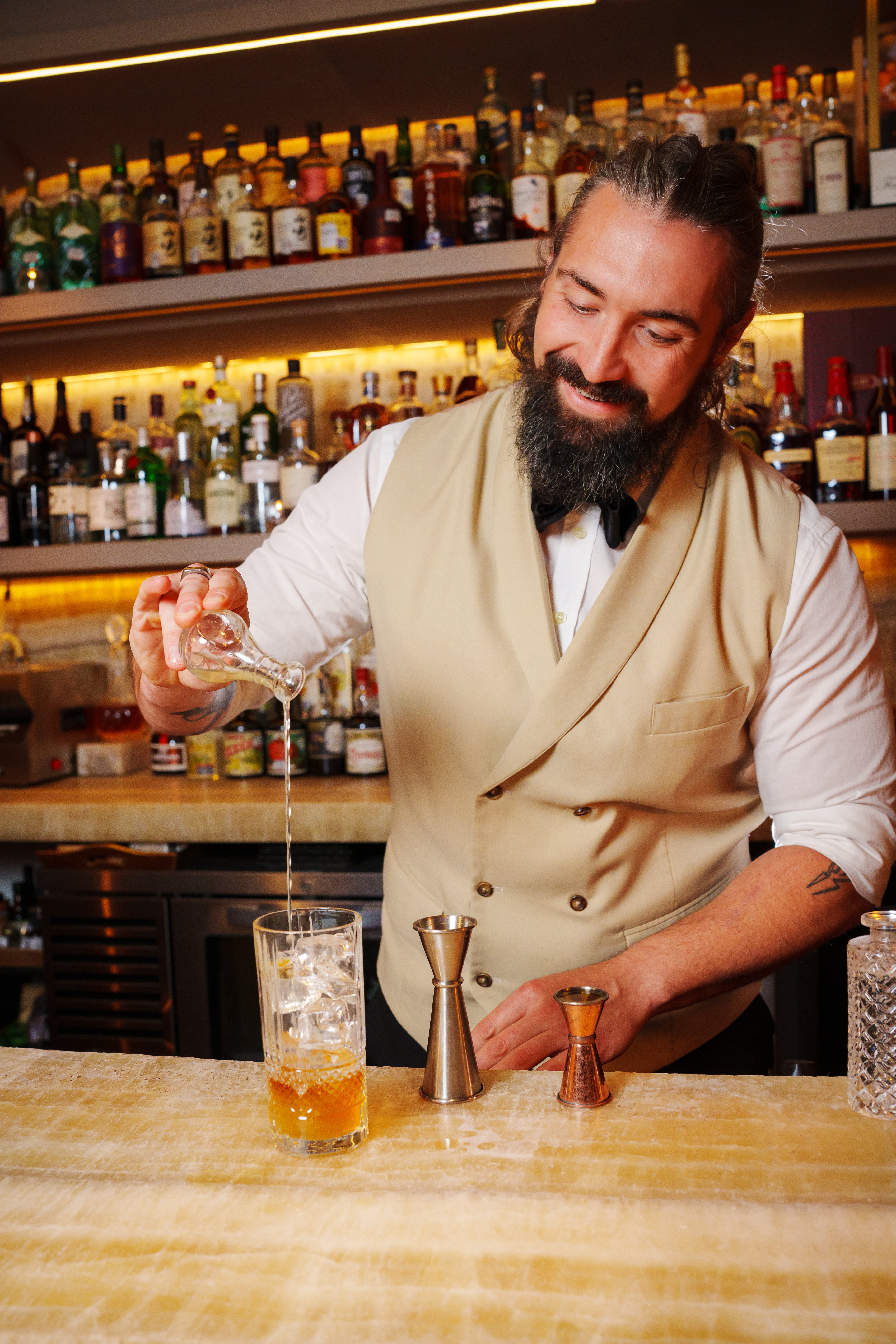 a man pouring liquid into a glass