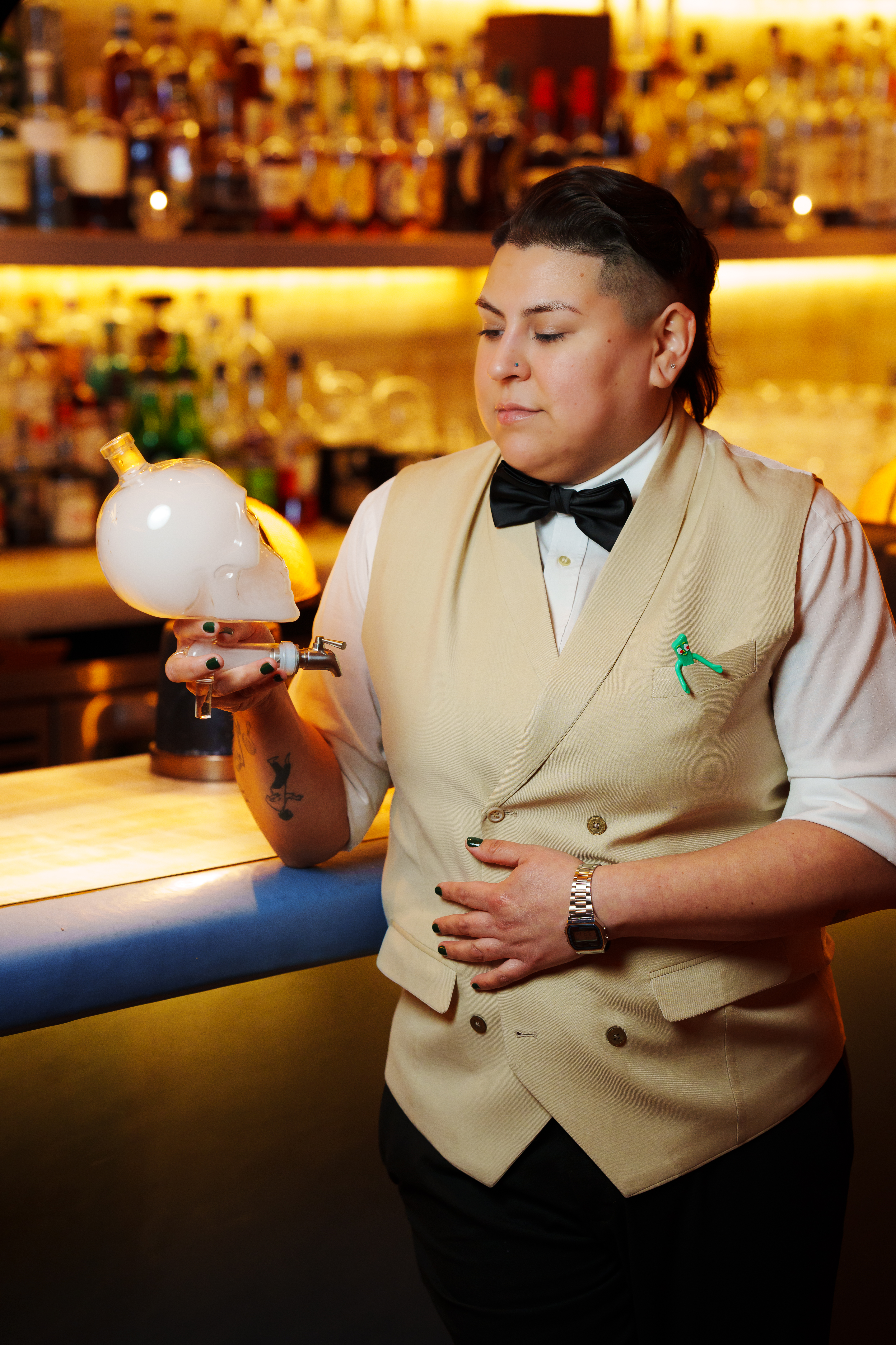 a woman in a vest holding a glass object