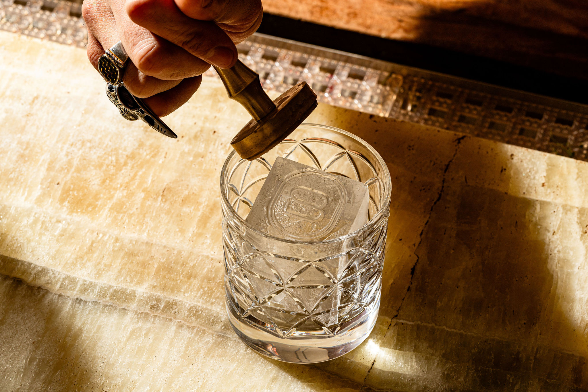 a hand holding a stamp over a glass of water