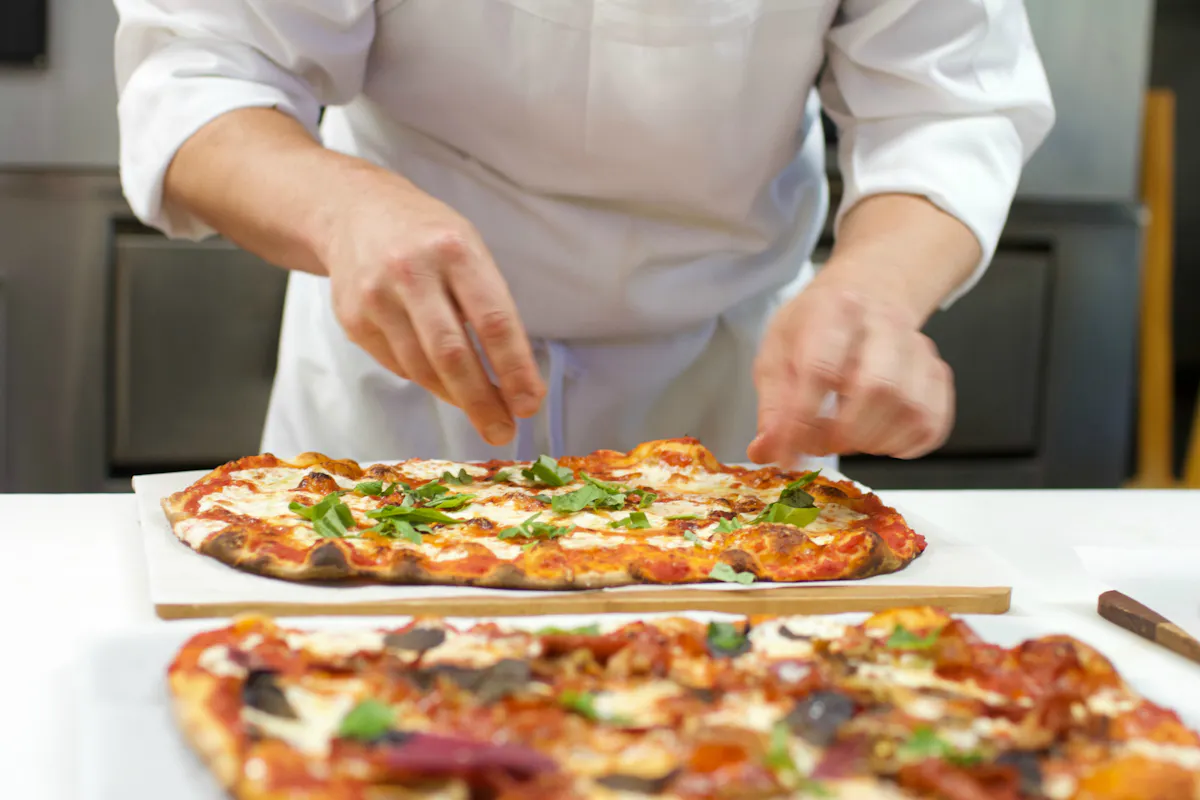 a person is cutting into a pizza