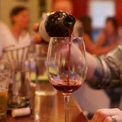 a person sitting at a table with wine glasses