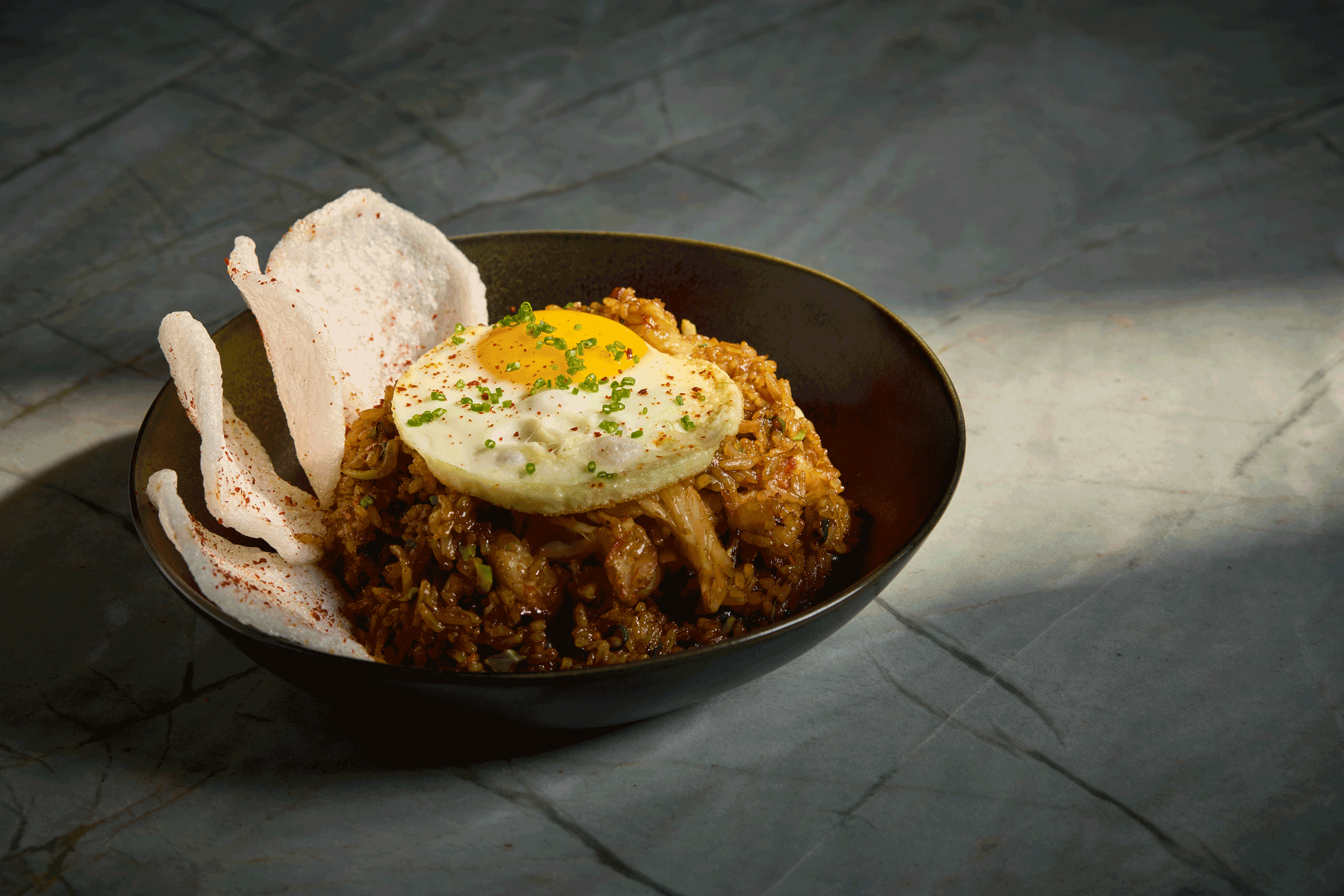 a bowl of food with a fried egg on top