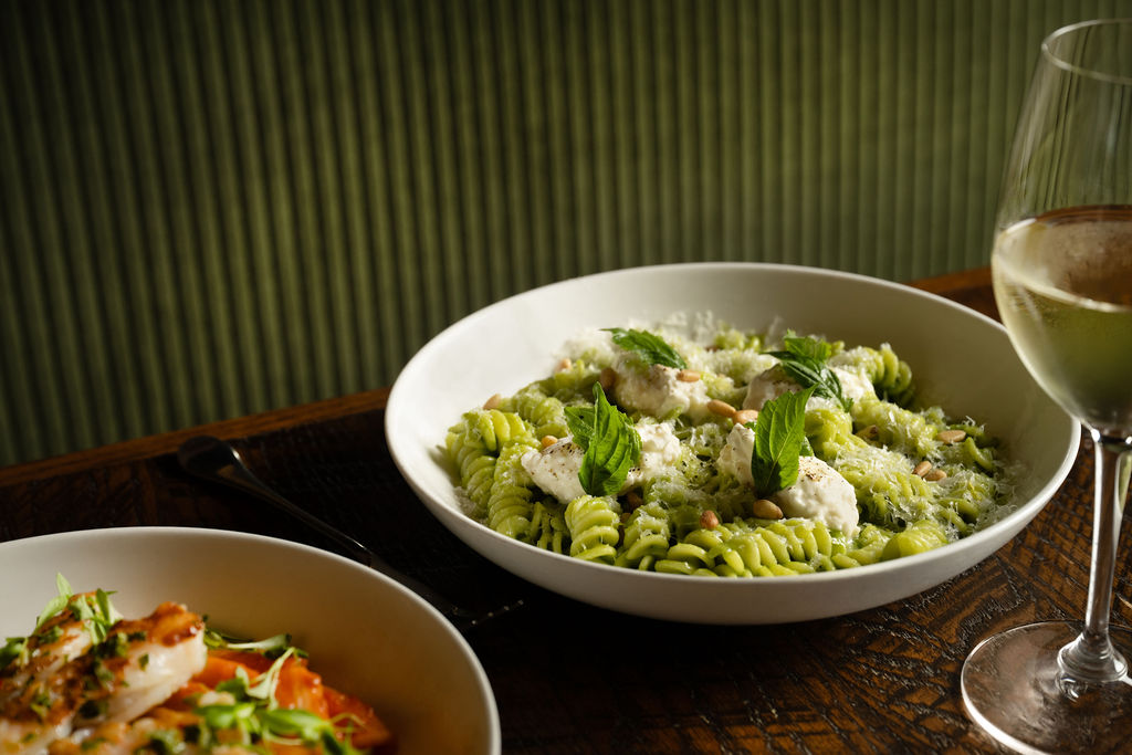 a bowl of pasta with cheese and basil