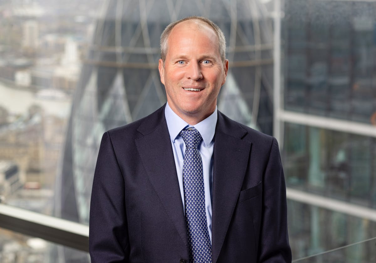 a man wearing a suit and tie standing in front of a building