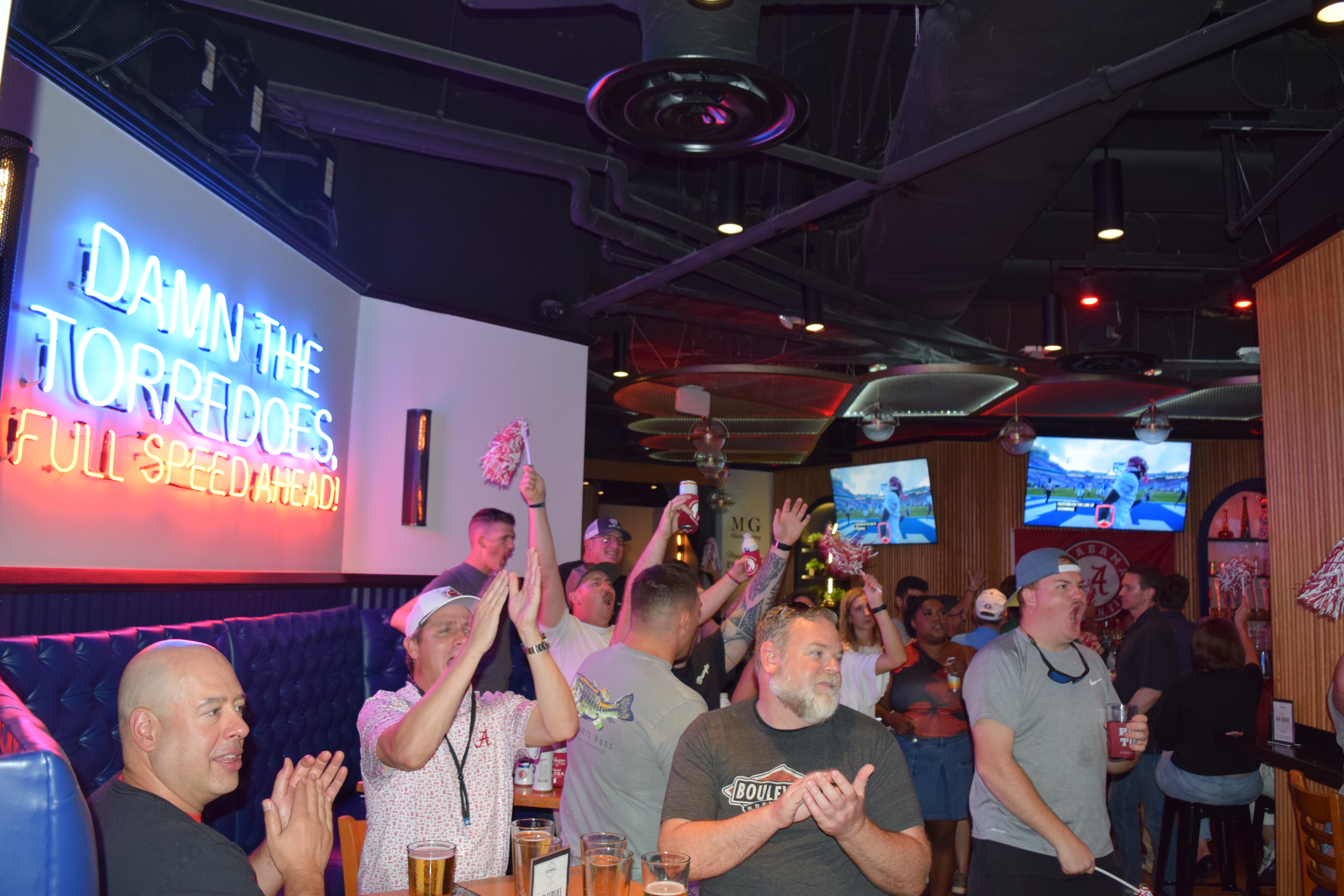 a group of people clapping in a bar
