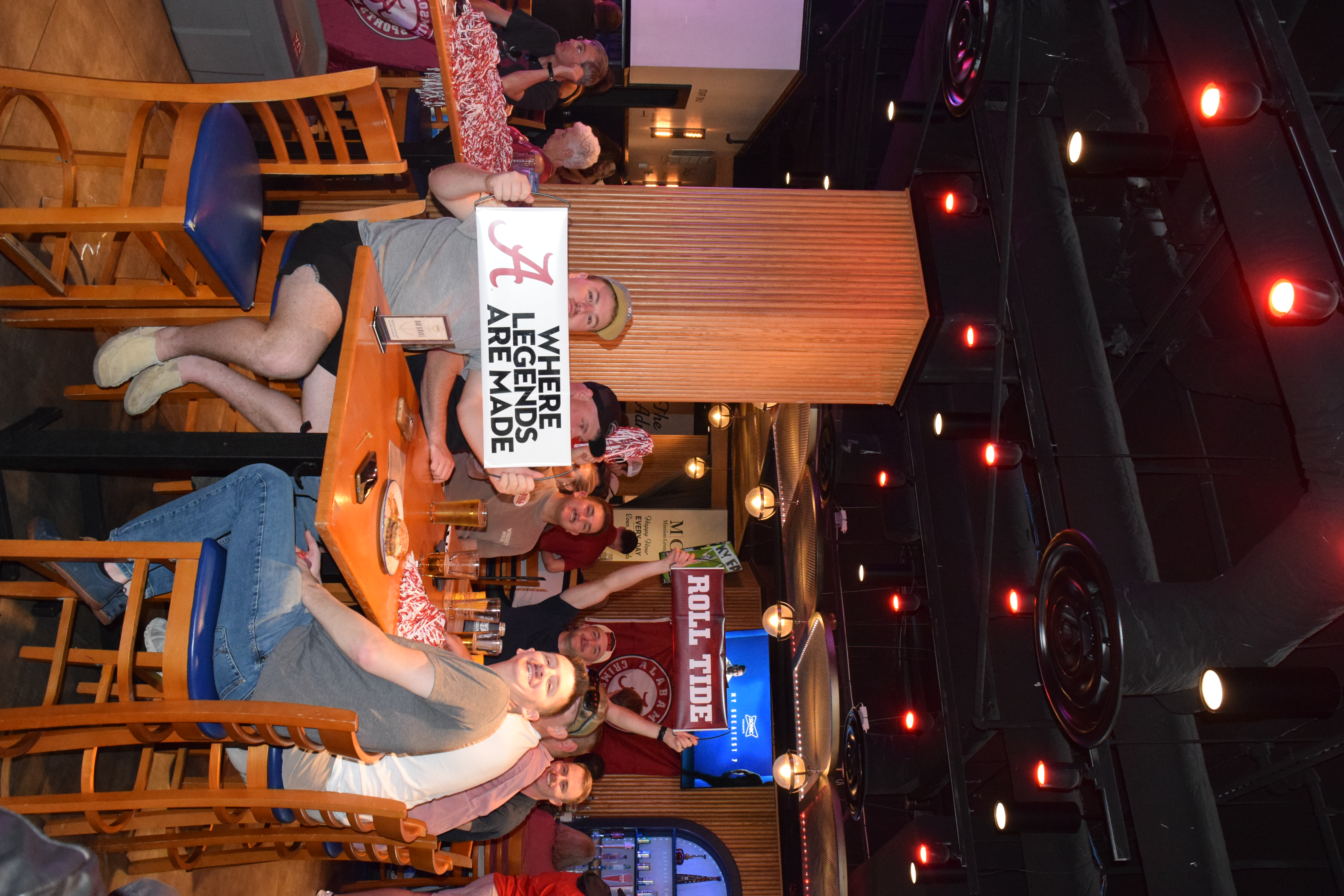 a group of people sitting at a table with a sign