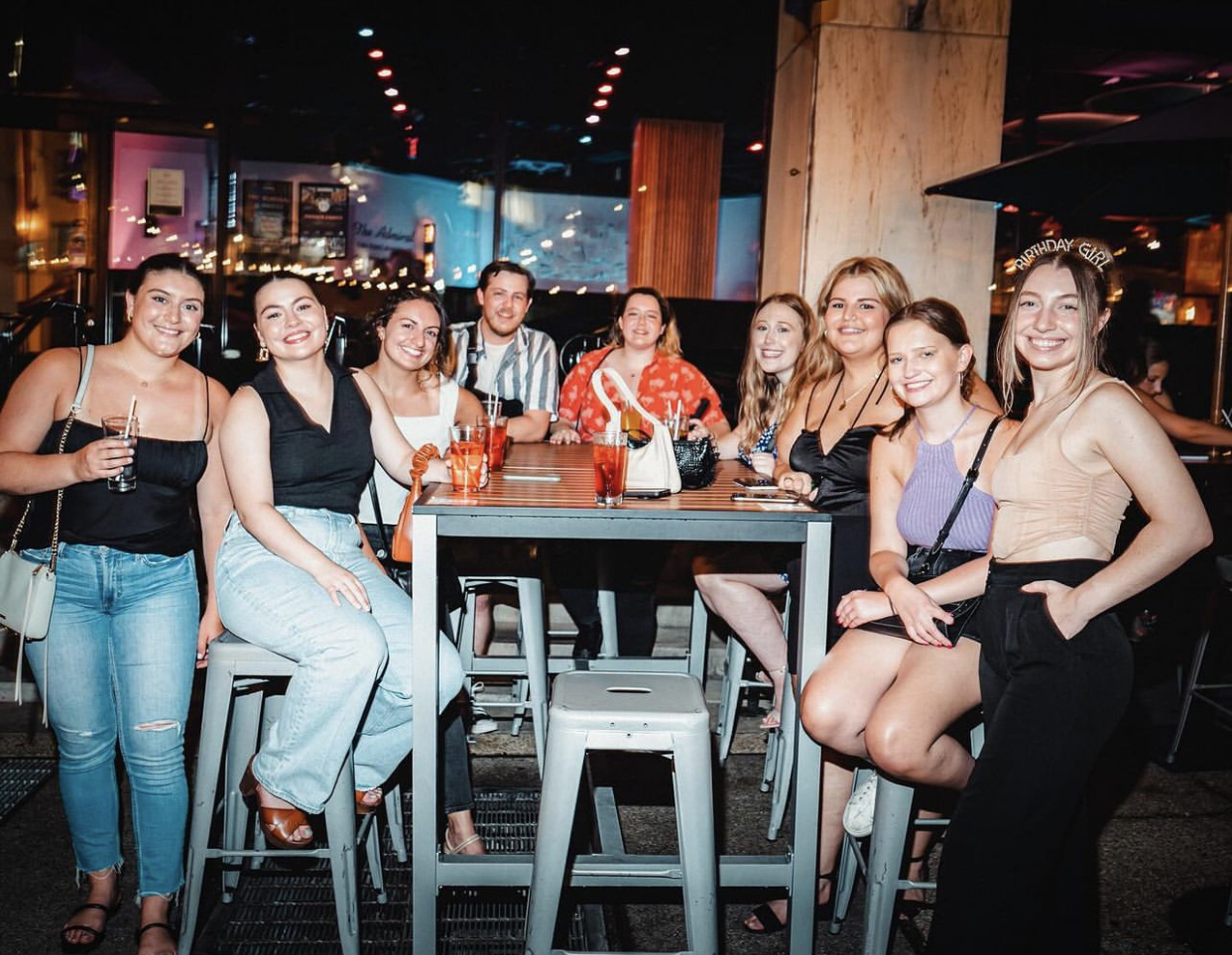 a group of people sitting at a table posing for the camera
