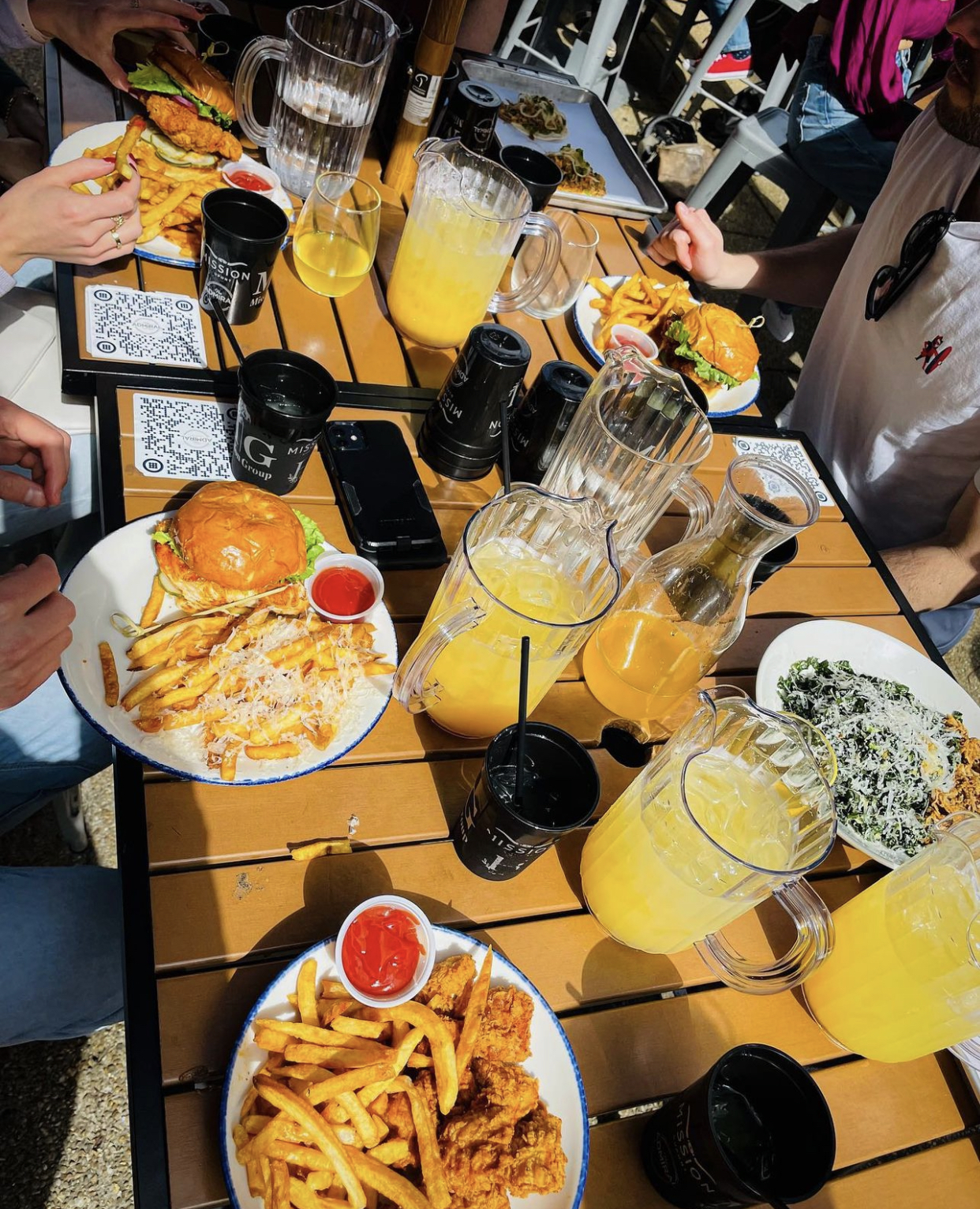 a group of people sitting at a table with food