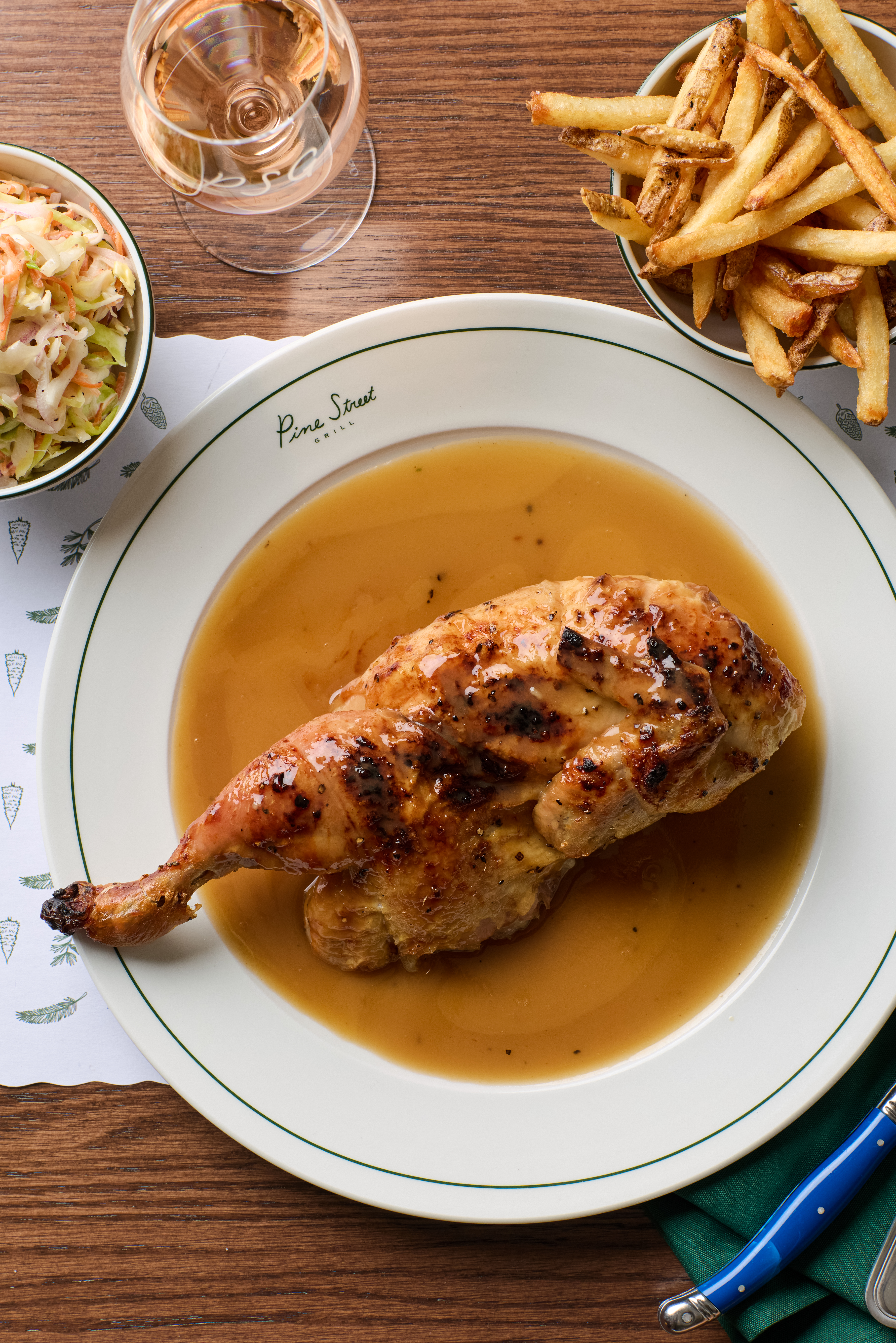 a plate of food with a side of fries and a bowl of coleslaw