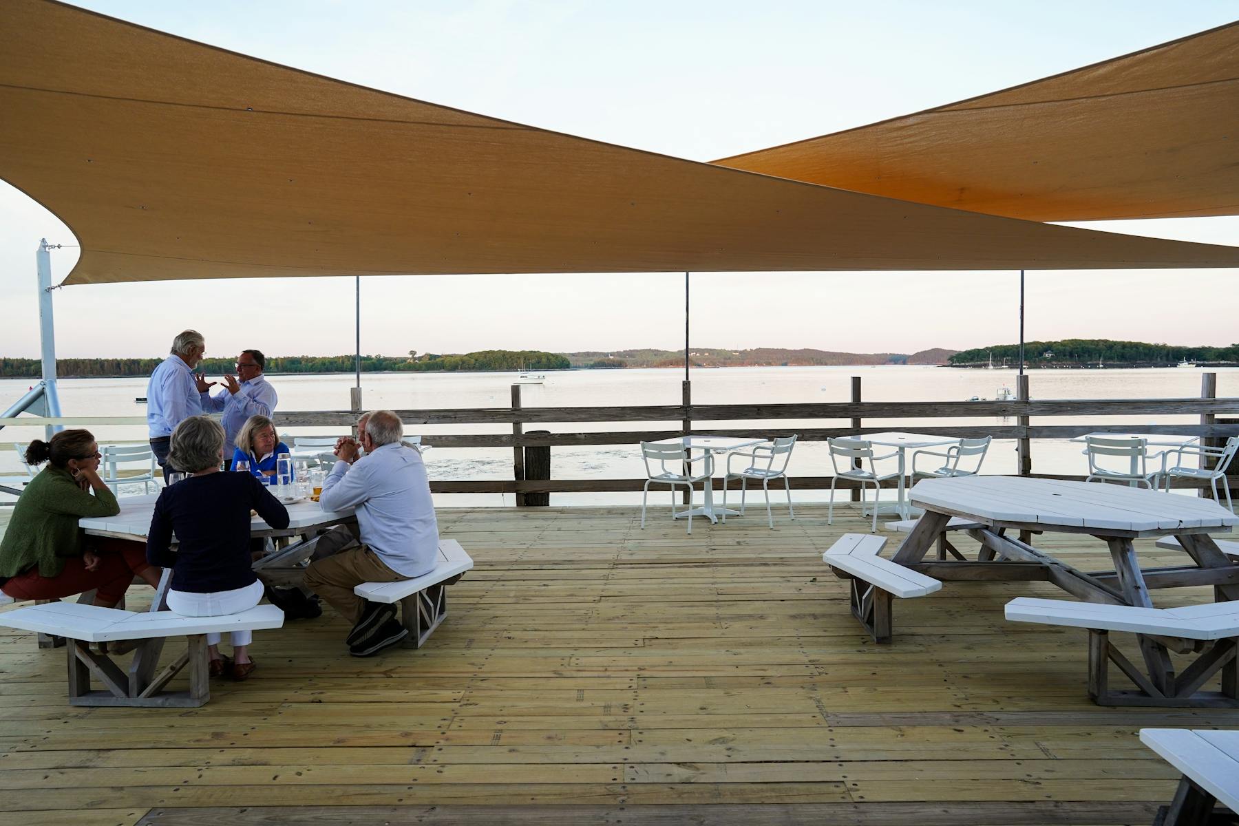 a group of people sitting on a bench on the deck