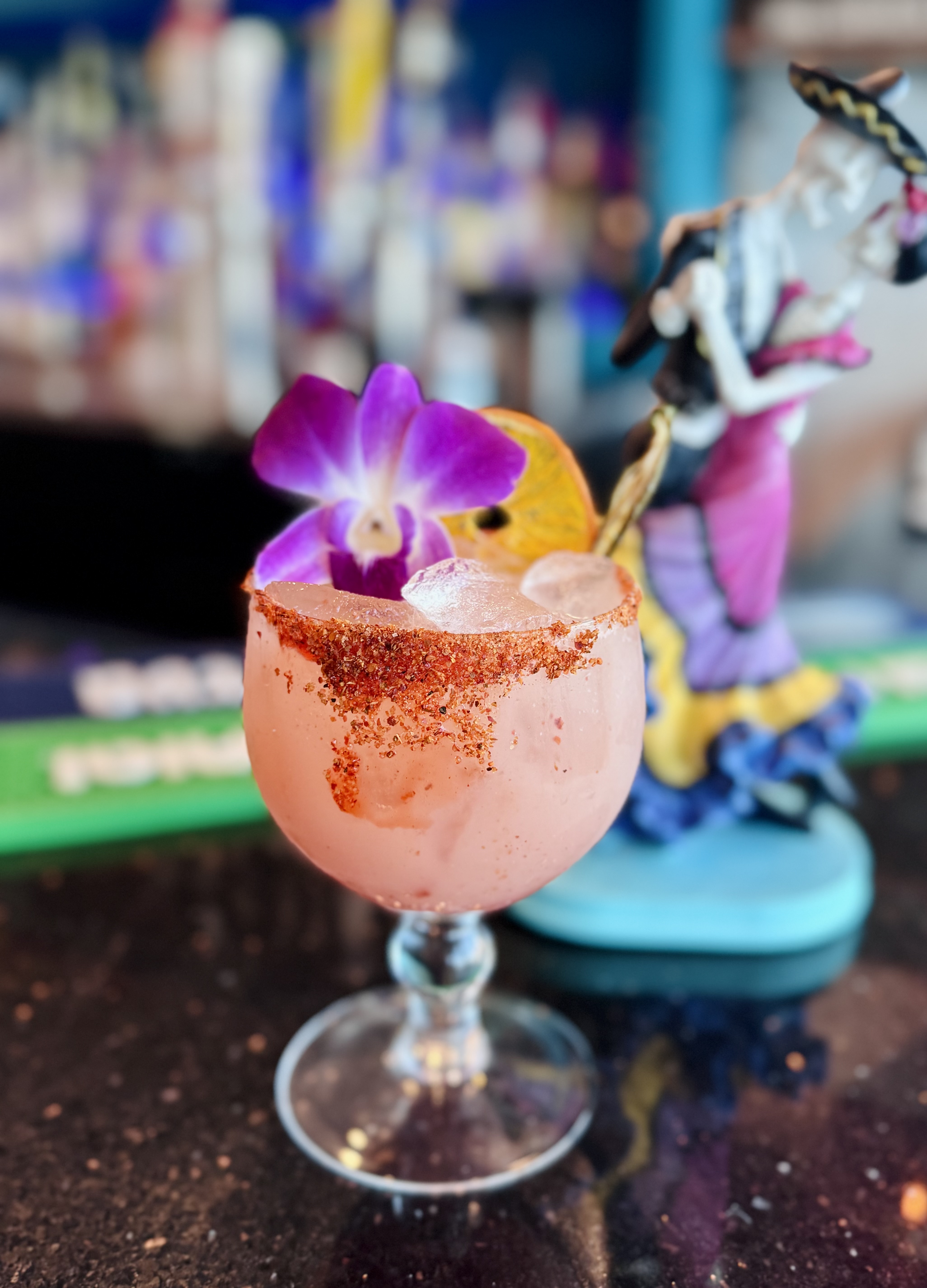 a pink drink with a flower and a figurine