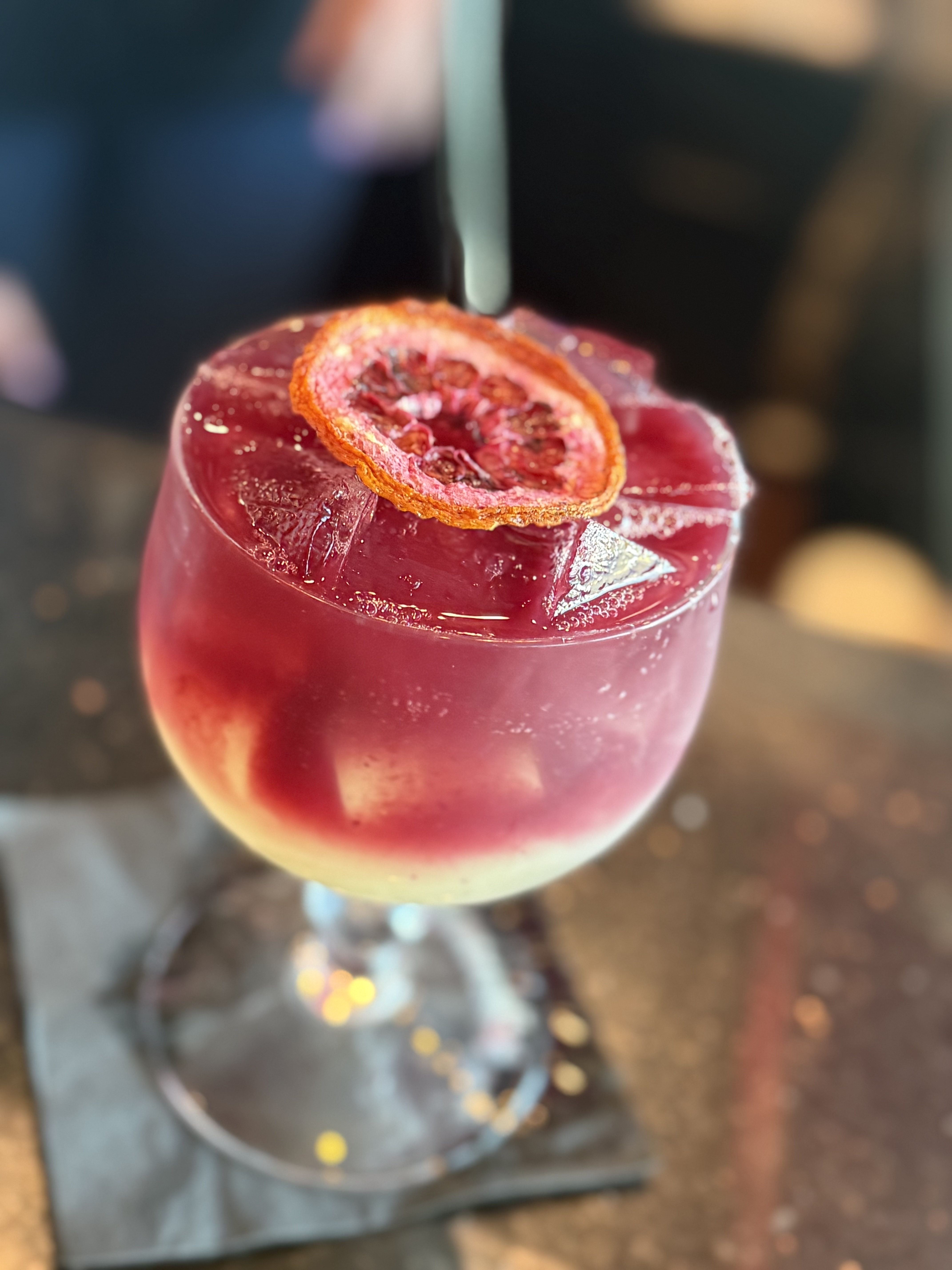 a glass with a drink and a slice of orange on top