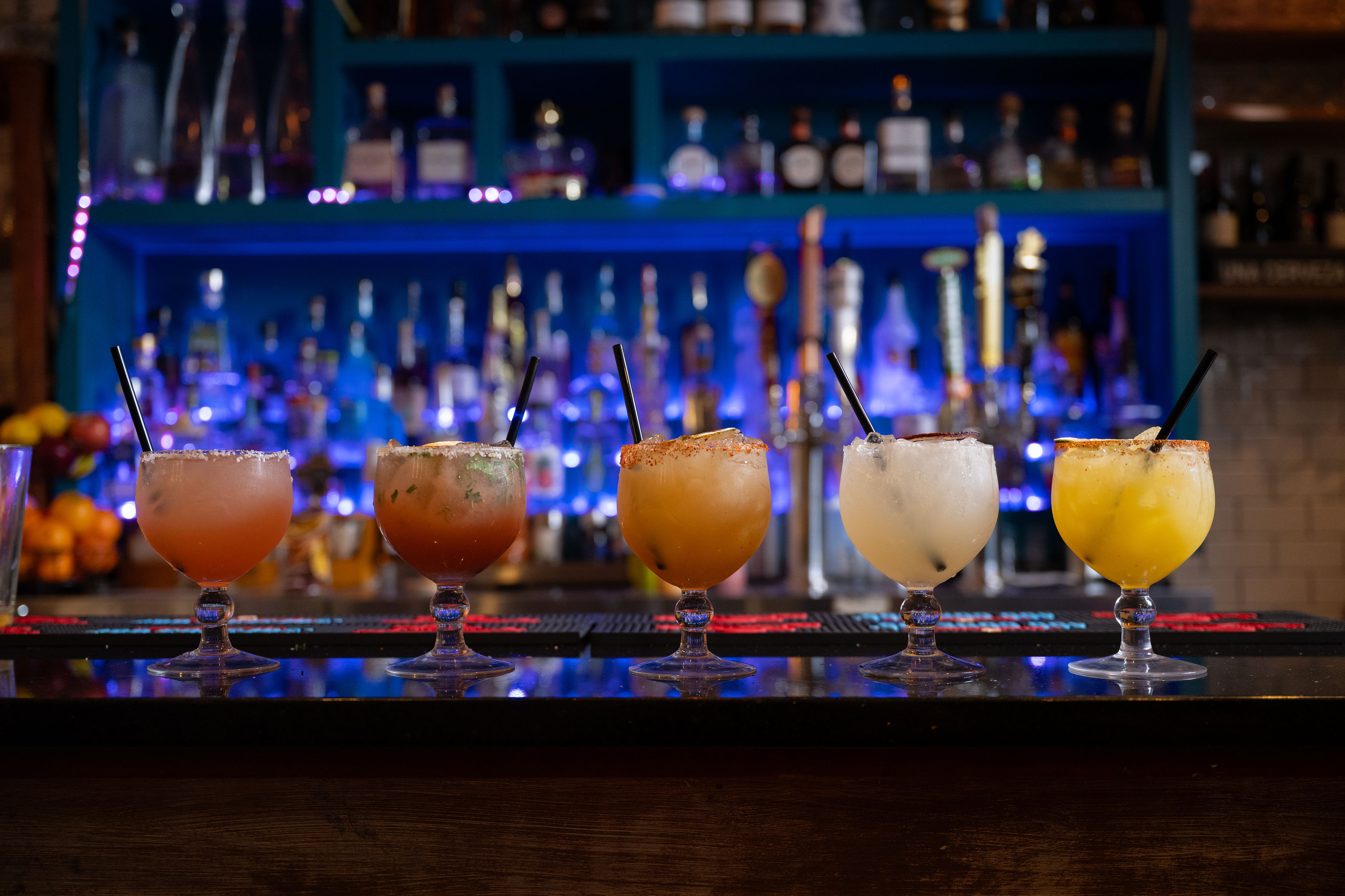 a row of drinks on a bar