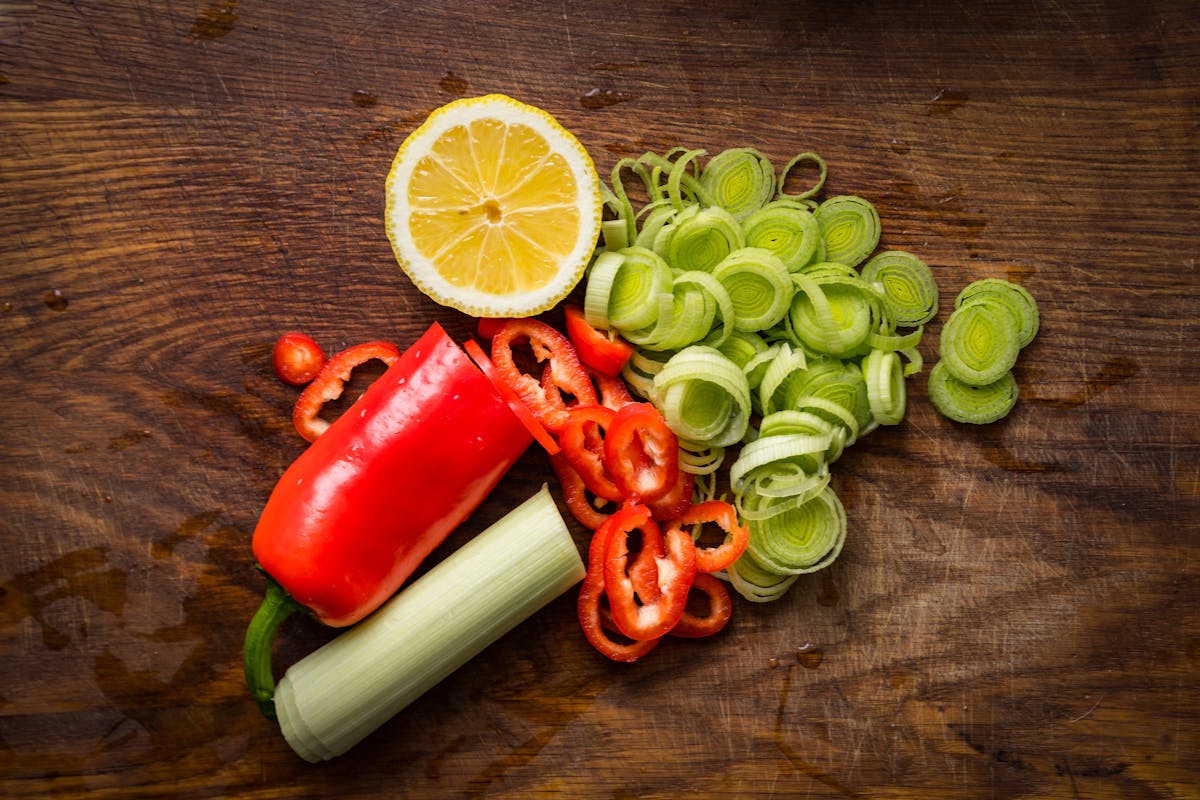 a green apple on top of a wooden cutting board