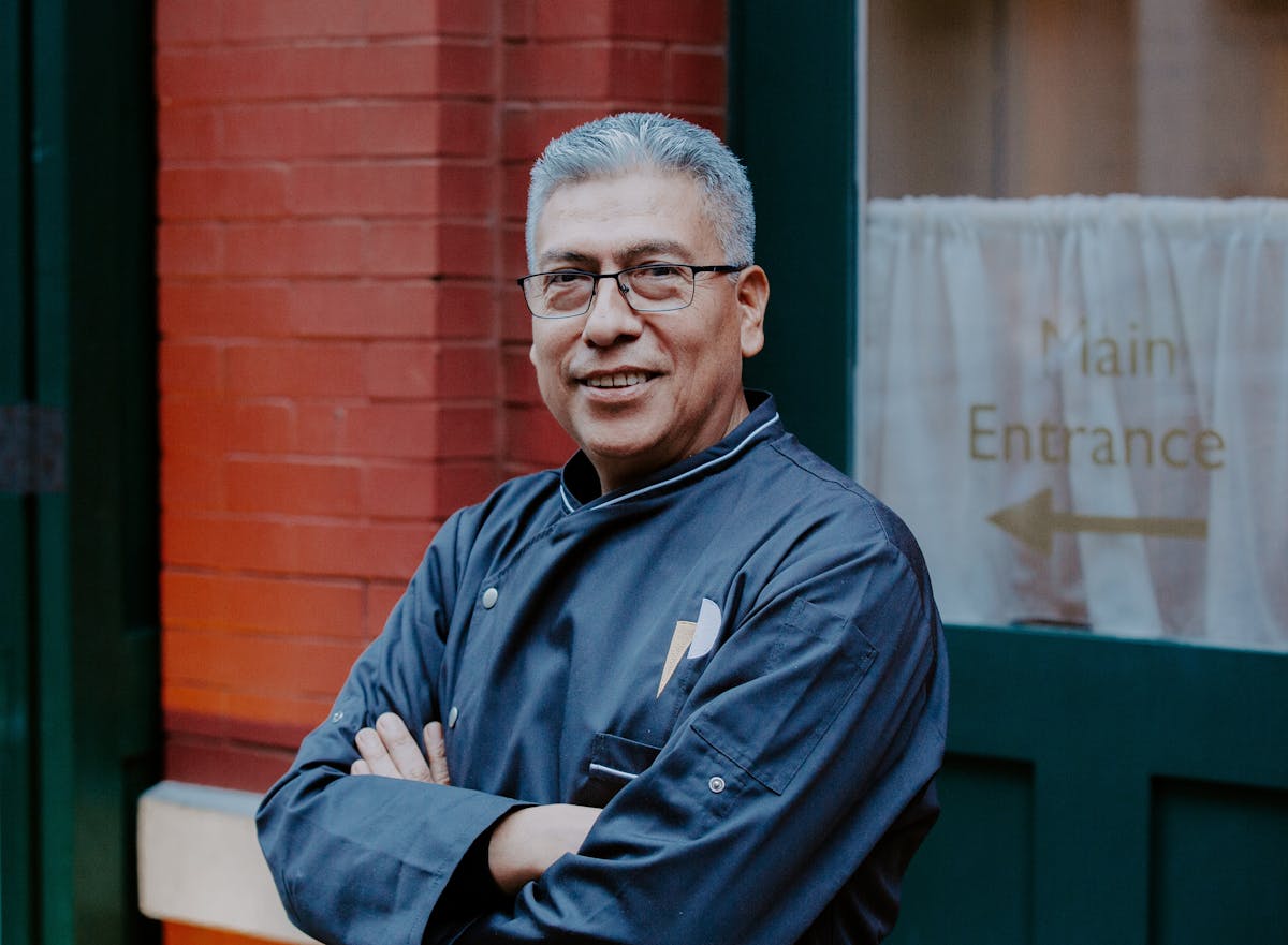 a man in a blue shirt standing in front of a building