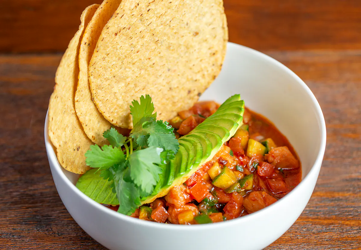 a bowl of soup with avocado