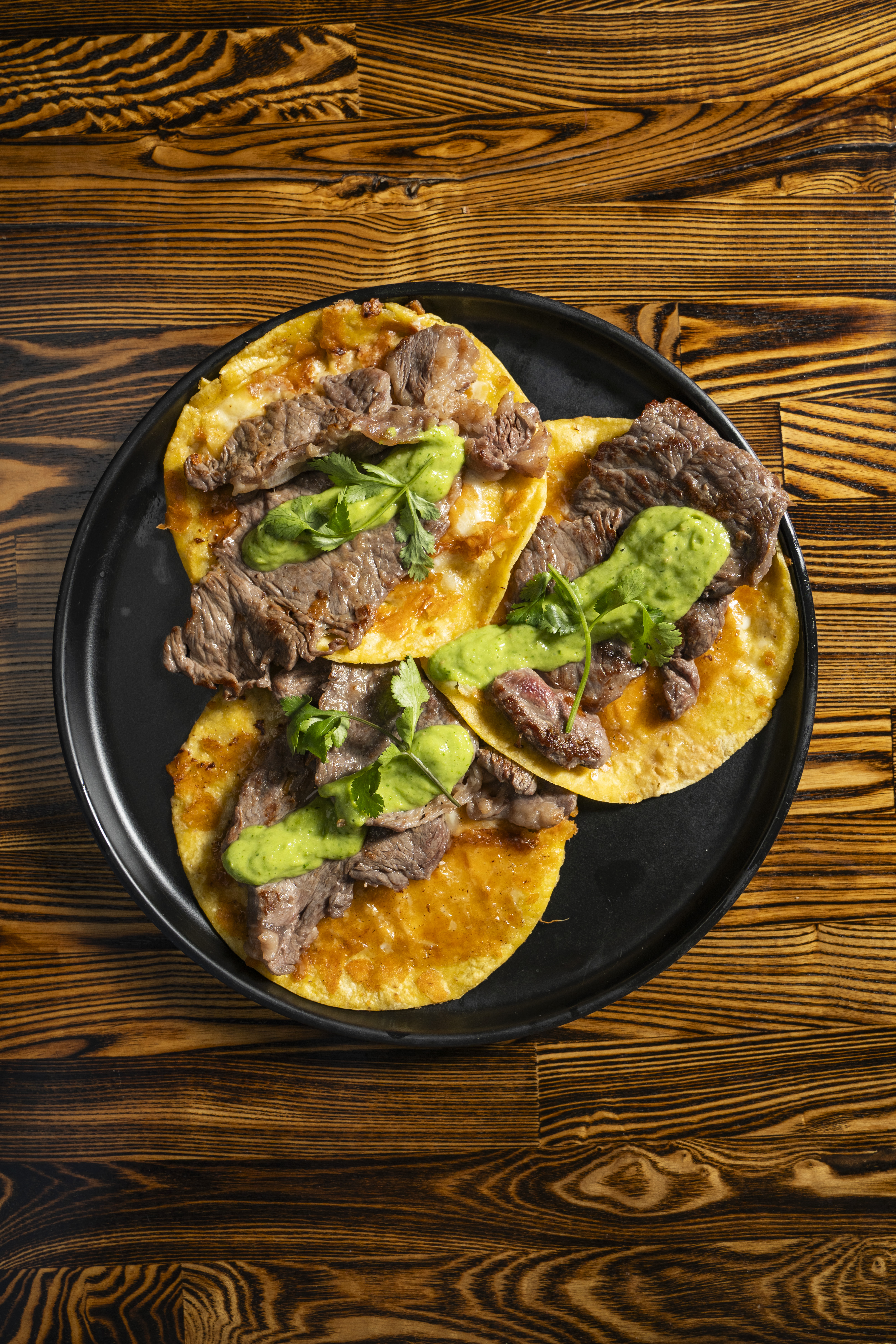 a plate of tacos with meat and sauce
