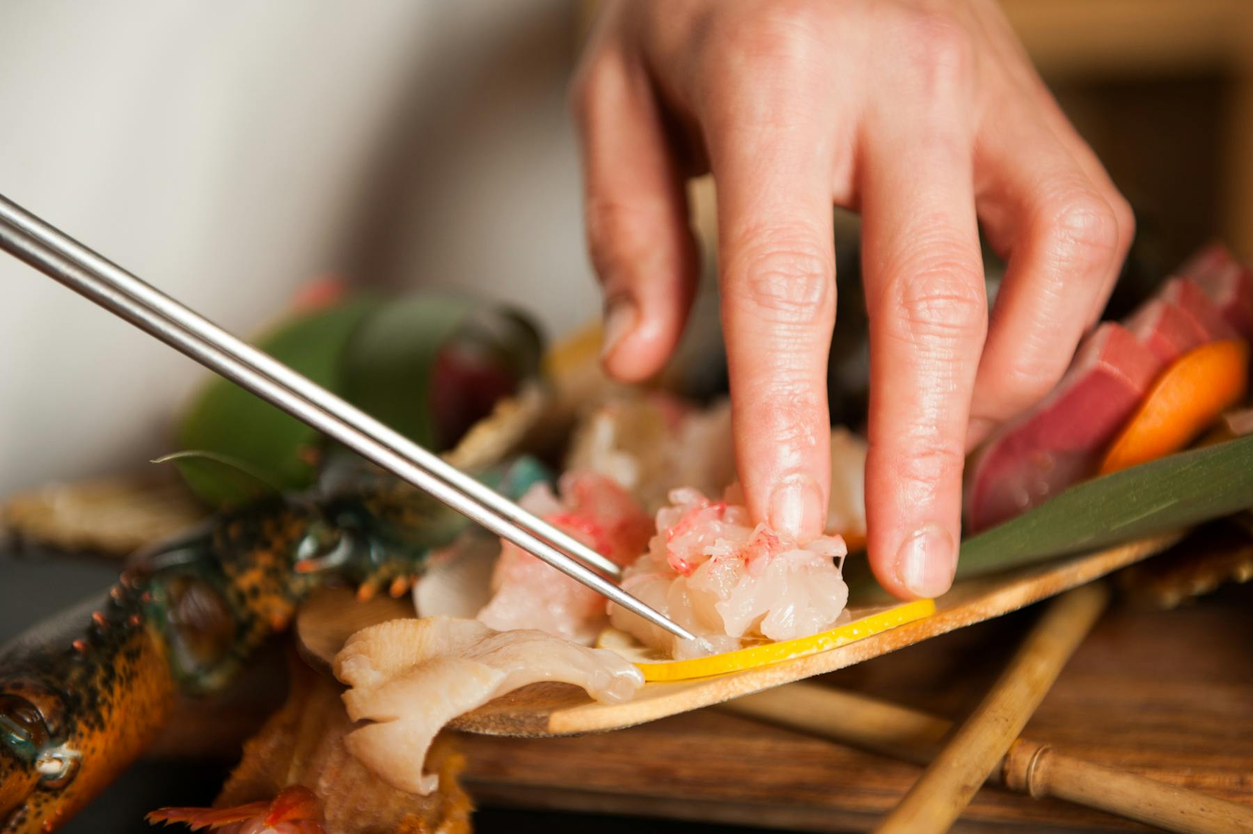 a hand holding a fork and knife on a cutting board