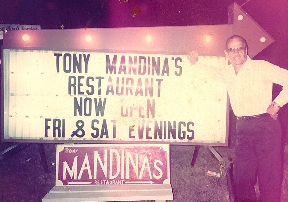 a person holding a sign posing for the camera