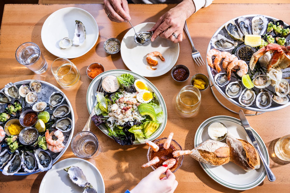 a table with food and hands reaching in 