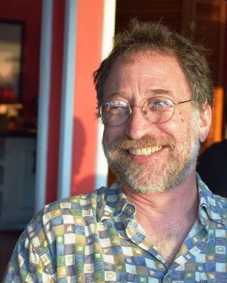 a close up of a man in glasses looking at the camera