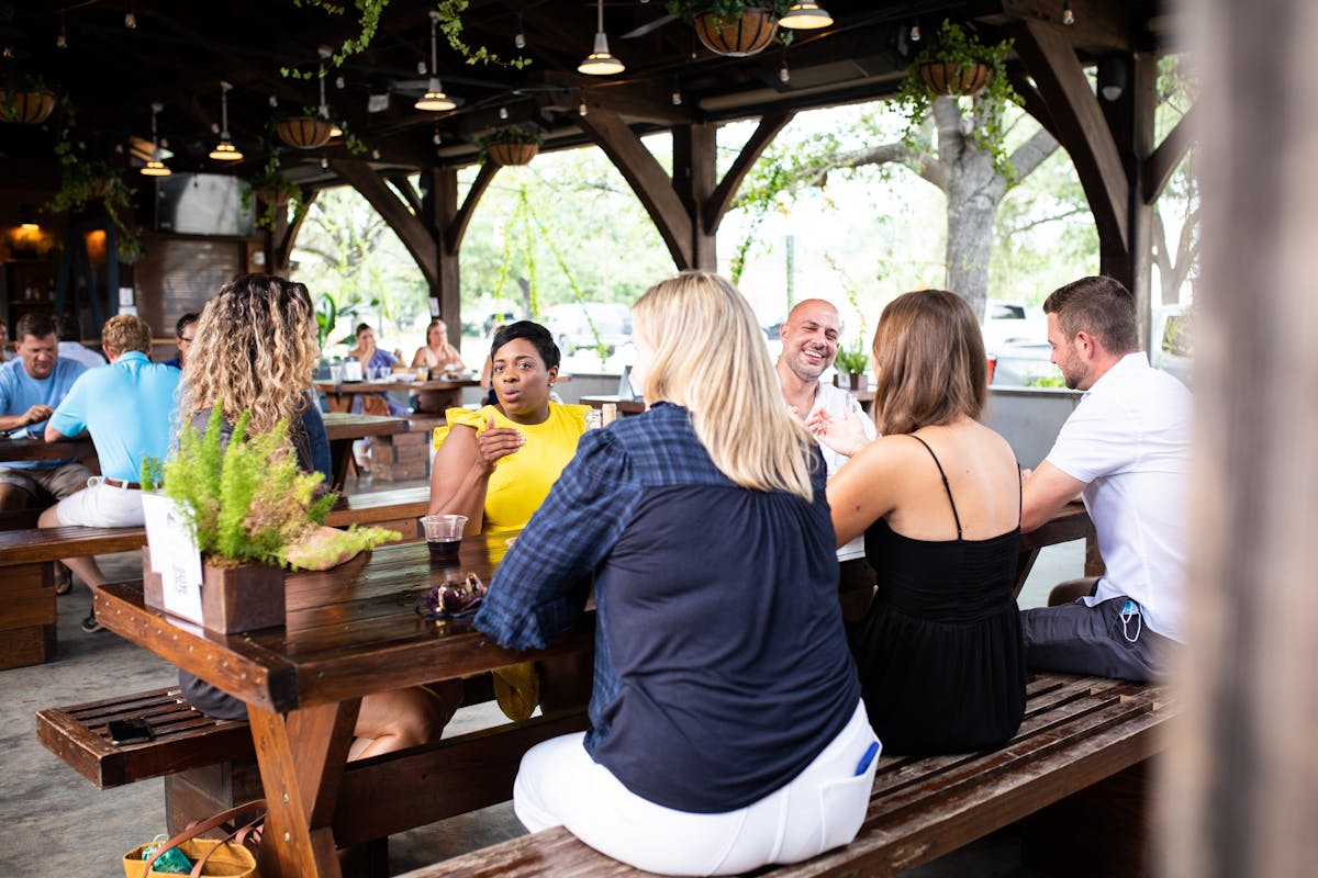 a group of people sitting at a picnic table