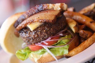 a close up of a hamburger topped with cheese