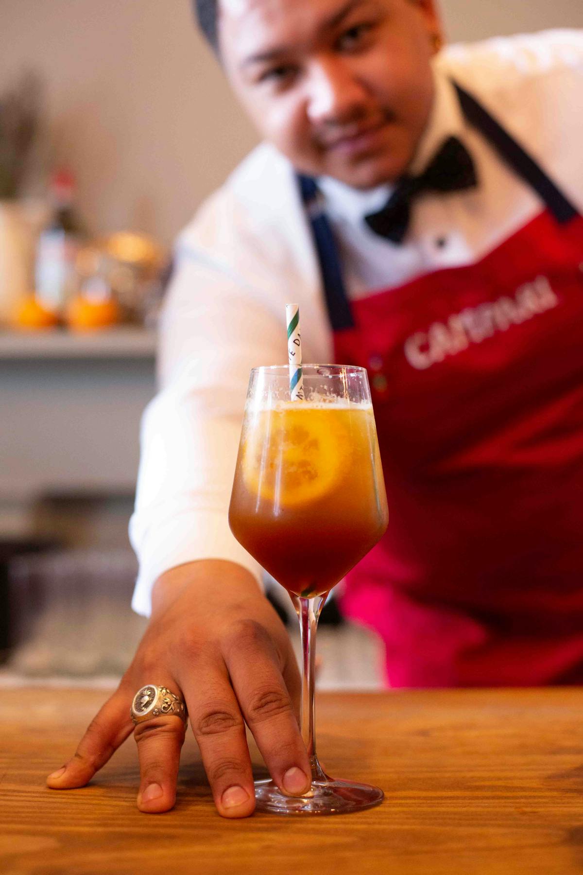 a person holding a glass of beer on a table