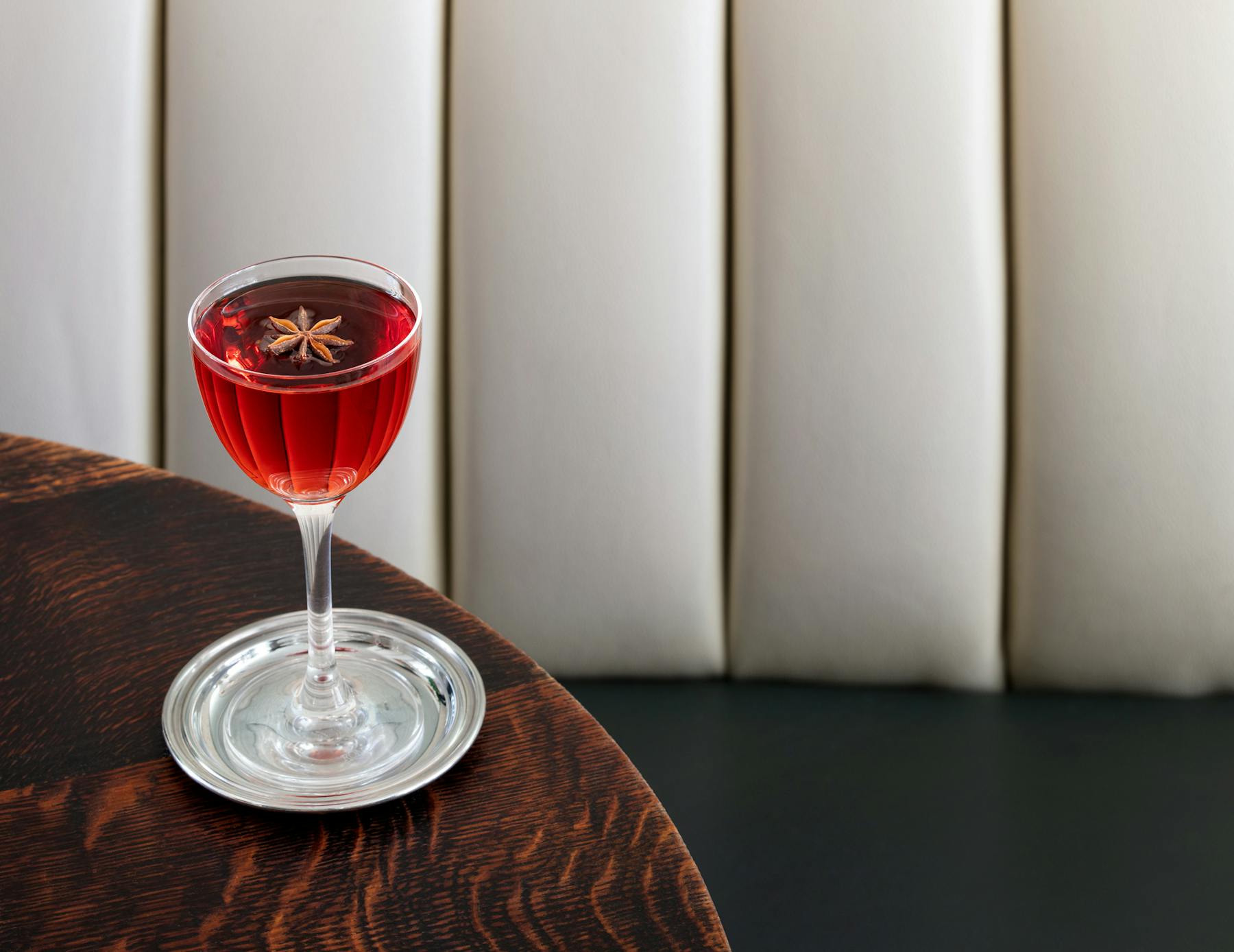 a glass of red wine on a table