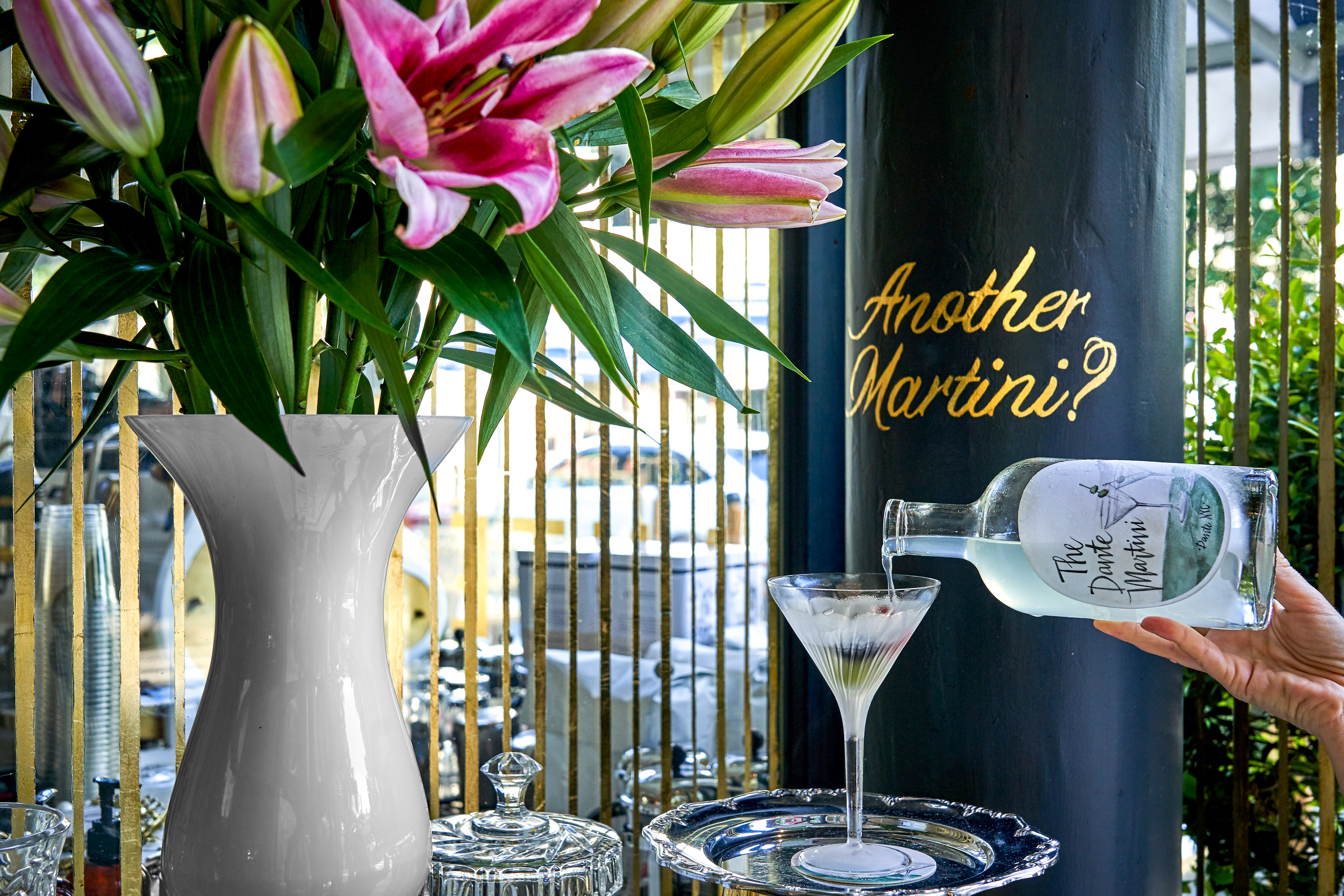 a vase of flowers on a table next to a glass of wine