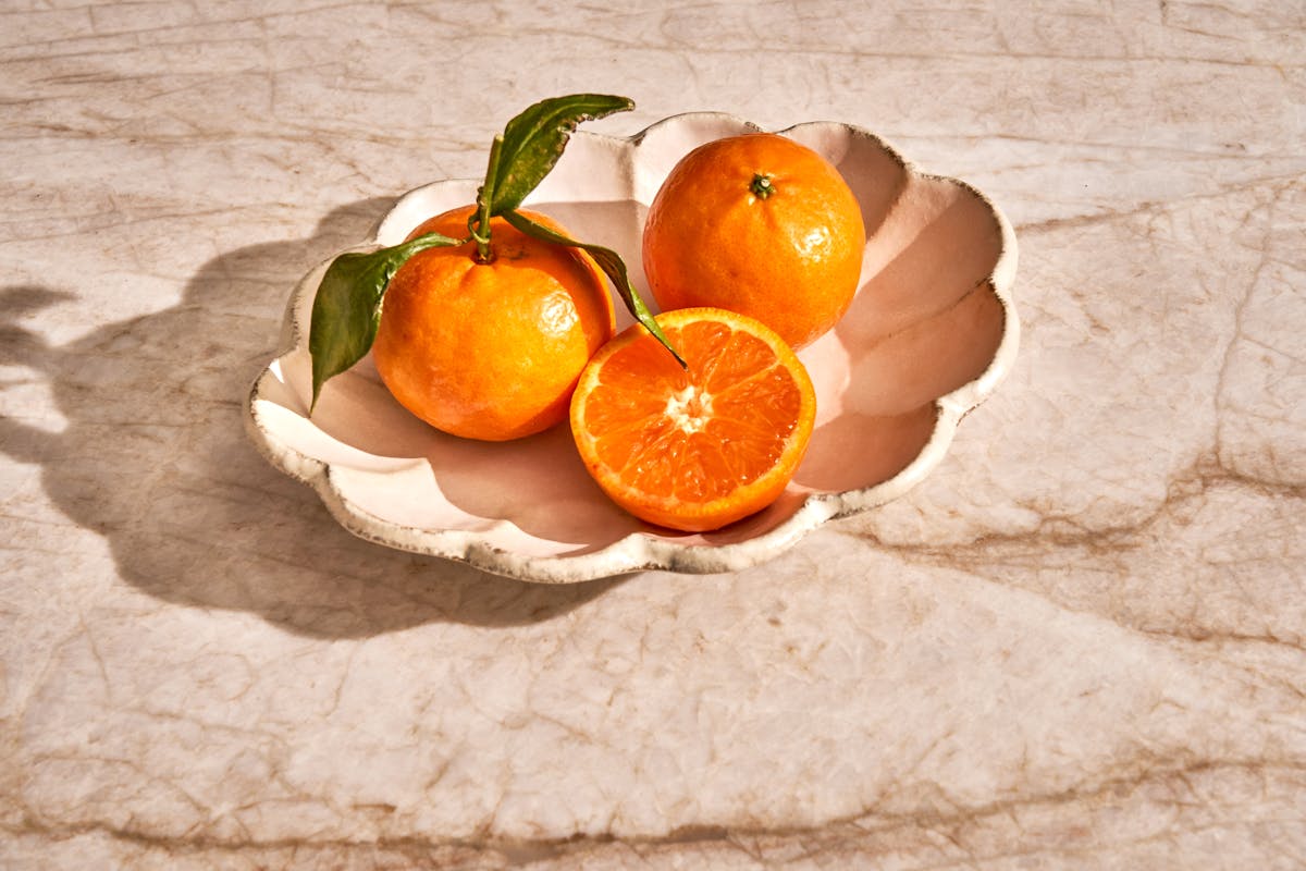 a bowl of oranges on a table