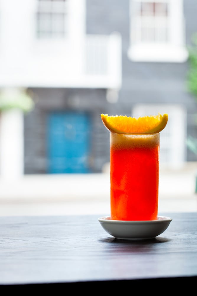 a close up of a glass of a garibaldi  on a table